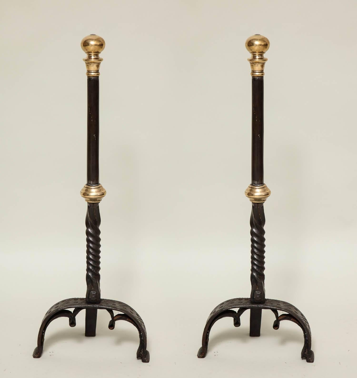 Fine pair of bold baroque bronze and wrought iron andirons, having suppressed bronze ball finials and collars, the wrought iron shafts with barley twist bases and standing on arched legs with trefoil arched details, the firedog portion reduced in