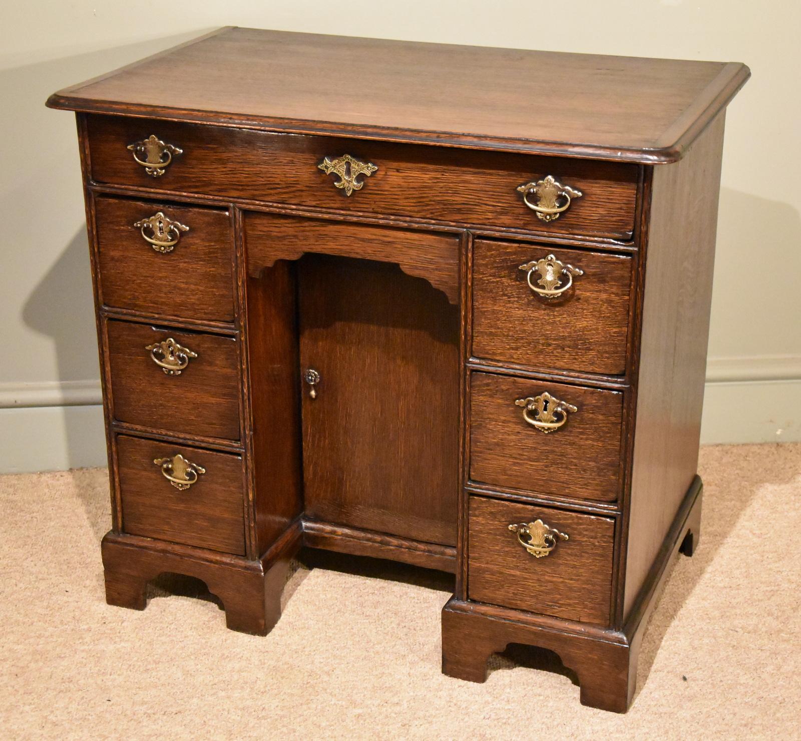 An unusually small George I oak kneehole desk of one large and six small drawers

Dimensions
Height 27