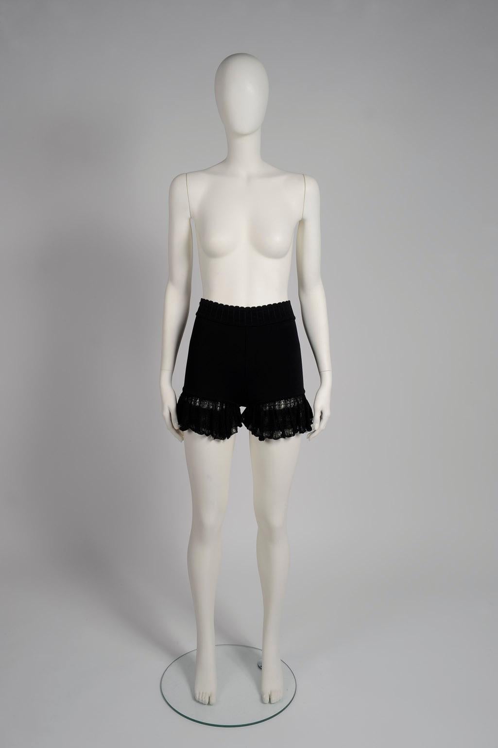 Part of the look 62 of the Alaïa 1992 Spring-Summer collection (see picture 3), these black mini shorts are made from Azzedine's signature stretch-knit which beautifully sculpts your curves. Trimmed with flouncy ruffles along the hem which provides