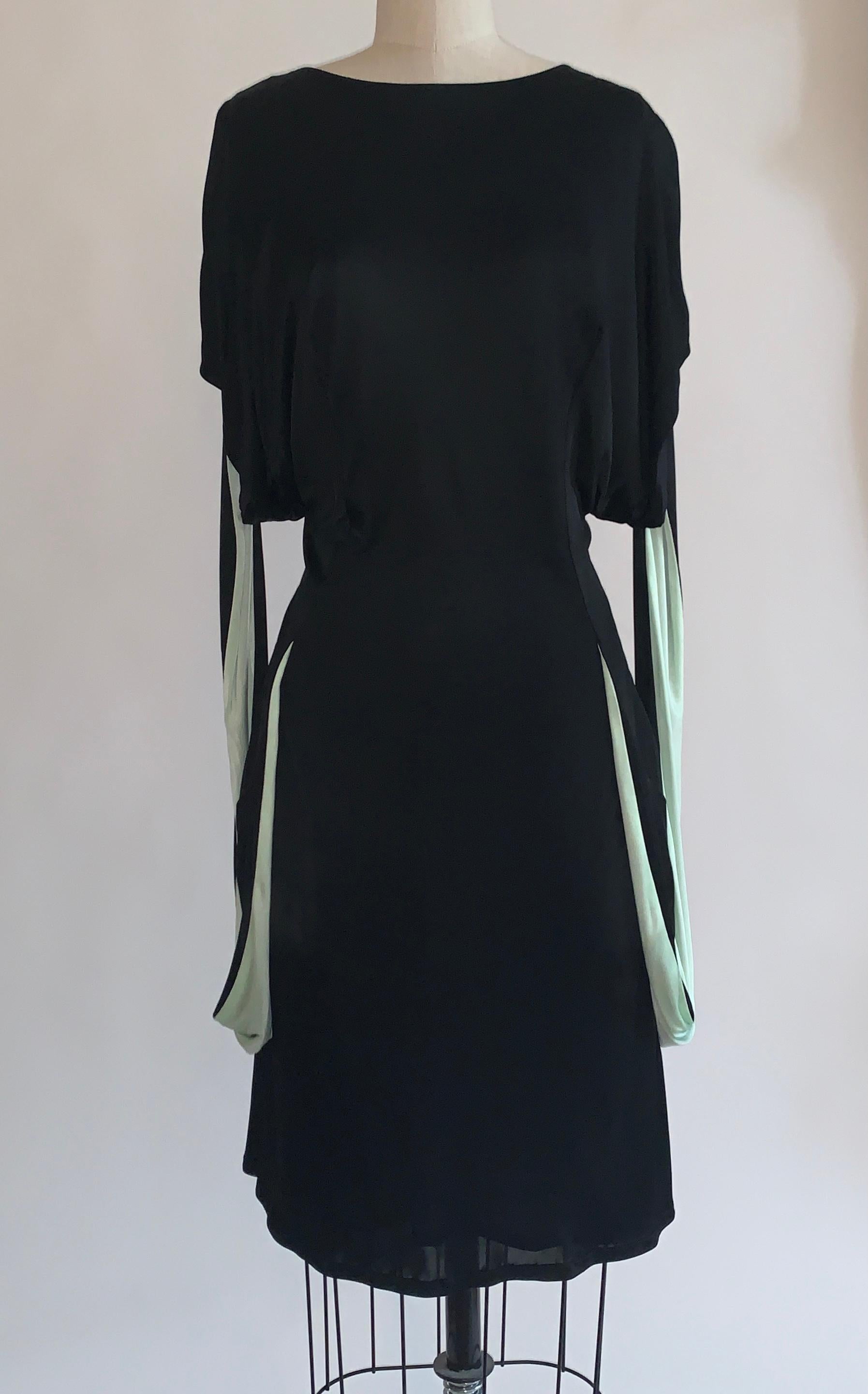 Alexander Mcqueen 2000s black draped jersey dress with amazing pale blue-green strap detail that hangs from sleeve to bottom and reconnects at hip seams. Side zip. 

100% rayon.
Lined in 75% polyamide, 25% lycra.

Made in Italy.

Size IT 42,