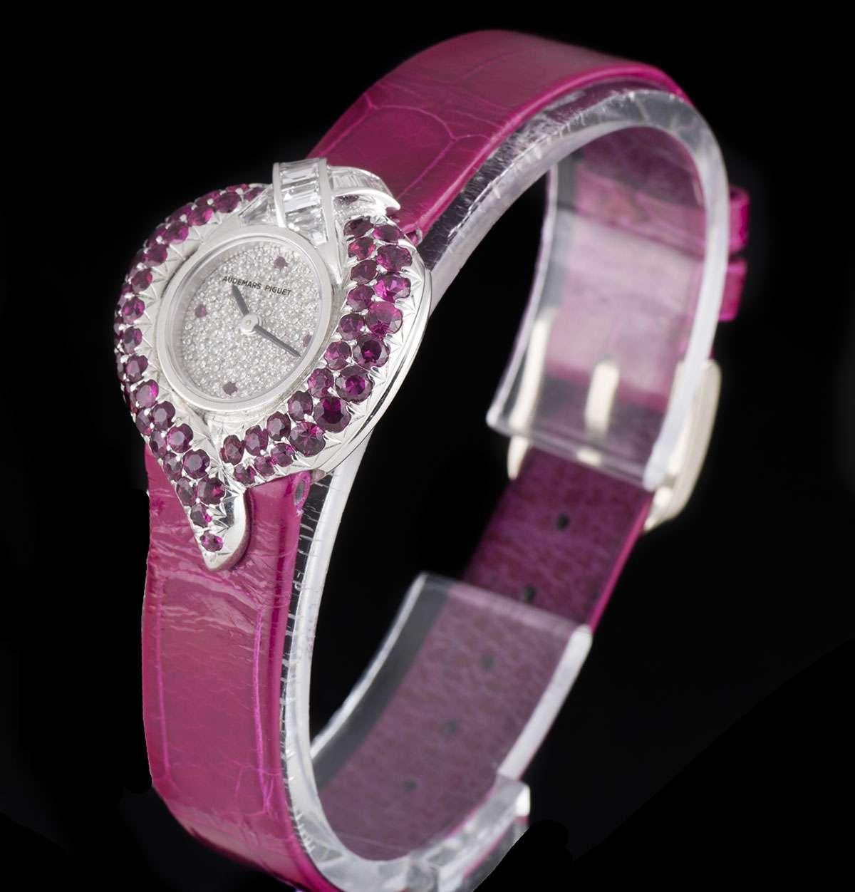 An Unworn 18k White Gold Piece Unique Diamond and Ruby Set NOS Ladies Dress Wristwatch, pave diamond dial with ruby hour markers at 3, 6, 9 and 12 0'clock, a fixed 18k white gold bezel set with approximately 51 round brilliant cut rubies (~1.50ct),