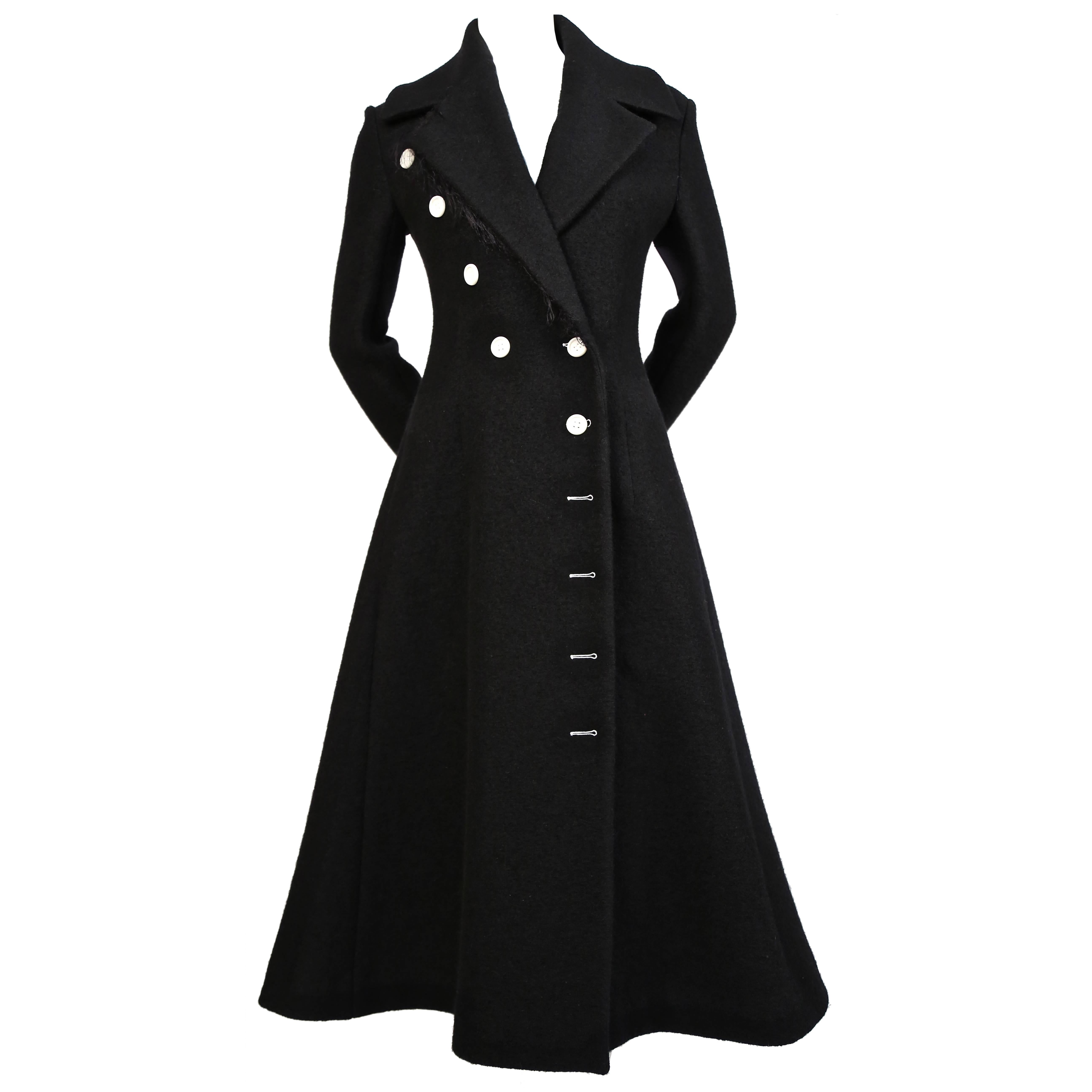Jet-black, textured wool coat with asymmetrical buttons and fringe trim at back of sleeves designed by Phoebe Philo for Celine as seen on the fall 2014 runway. French size 38 which fits a US 4. Approximate measurements: shoulders 16