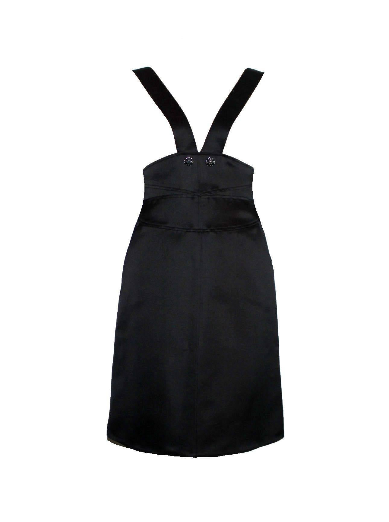A modern but classic version of the famous little black dress by Chanel
Consisting of two pieces, dress and coat
Dress features a deep V neck with straps joining at the waist.
Straps held at waist by 2 classy crystal CC logo buttons
Two front