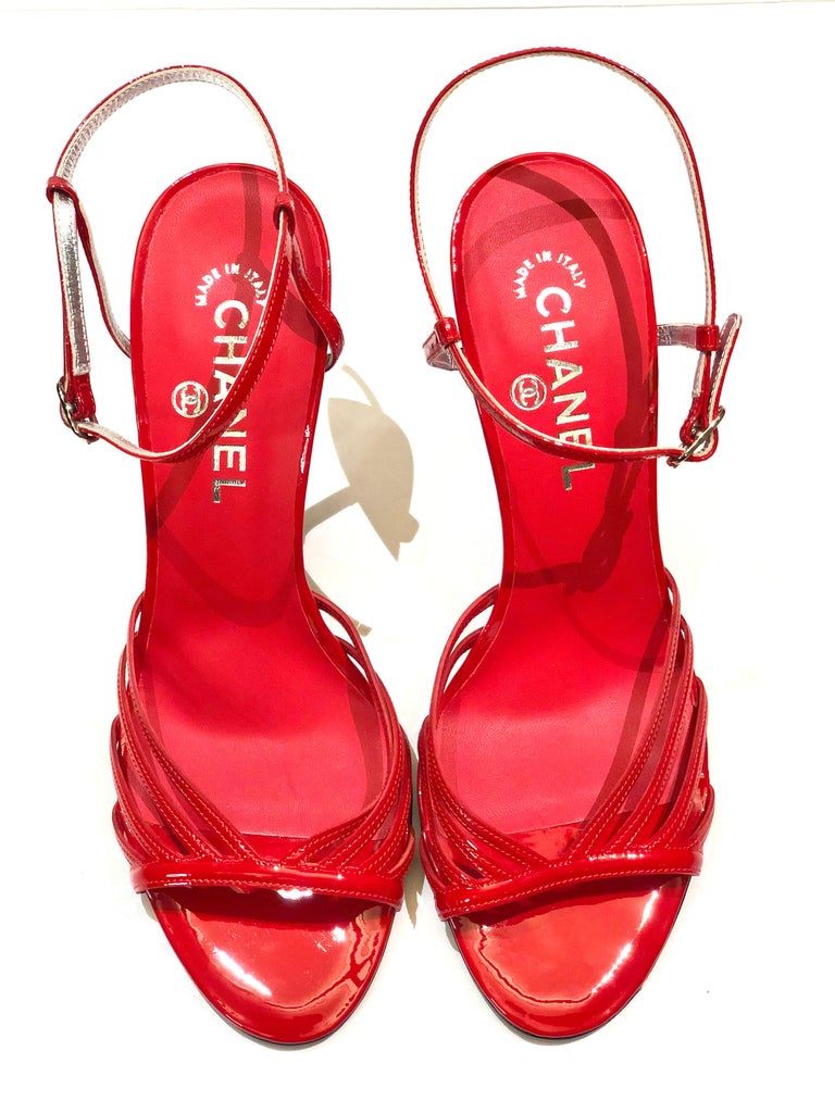 - Chanel red patent leather slingback sandals with silver metal hardware 
