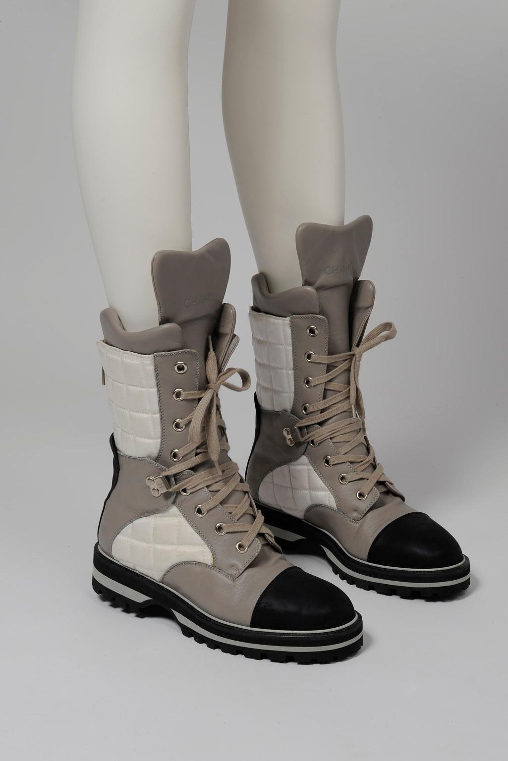 From the early Chanel Sport line and worn by Erin O'Connor at the fashion show (look n° 6/see picture 3), these never worn Chanel ankle boots have been made in Italy from white nylon, black and grey leather. Inspired by classic hiking styles, this