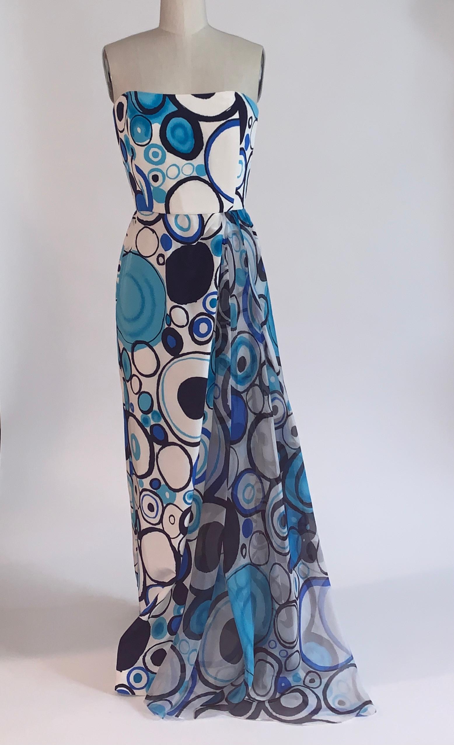 Blau-weißes, trägerloses Seidenkleid von Lily Samii mit abstraktem Kreismuster in Hell- und Marineblau.  Drapierter Chiffoneinsatz auf der Vorderseite. Seitlicher Schlitz vorne hinter der Drapierung. Korsettstäbchen am Mieder. Rückenreißverschluss