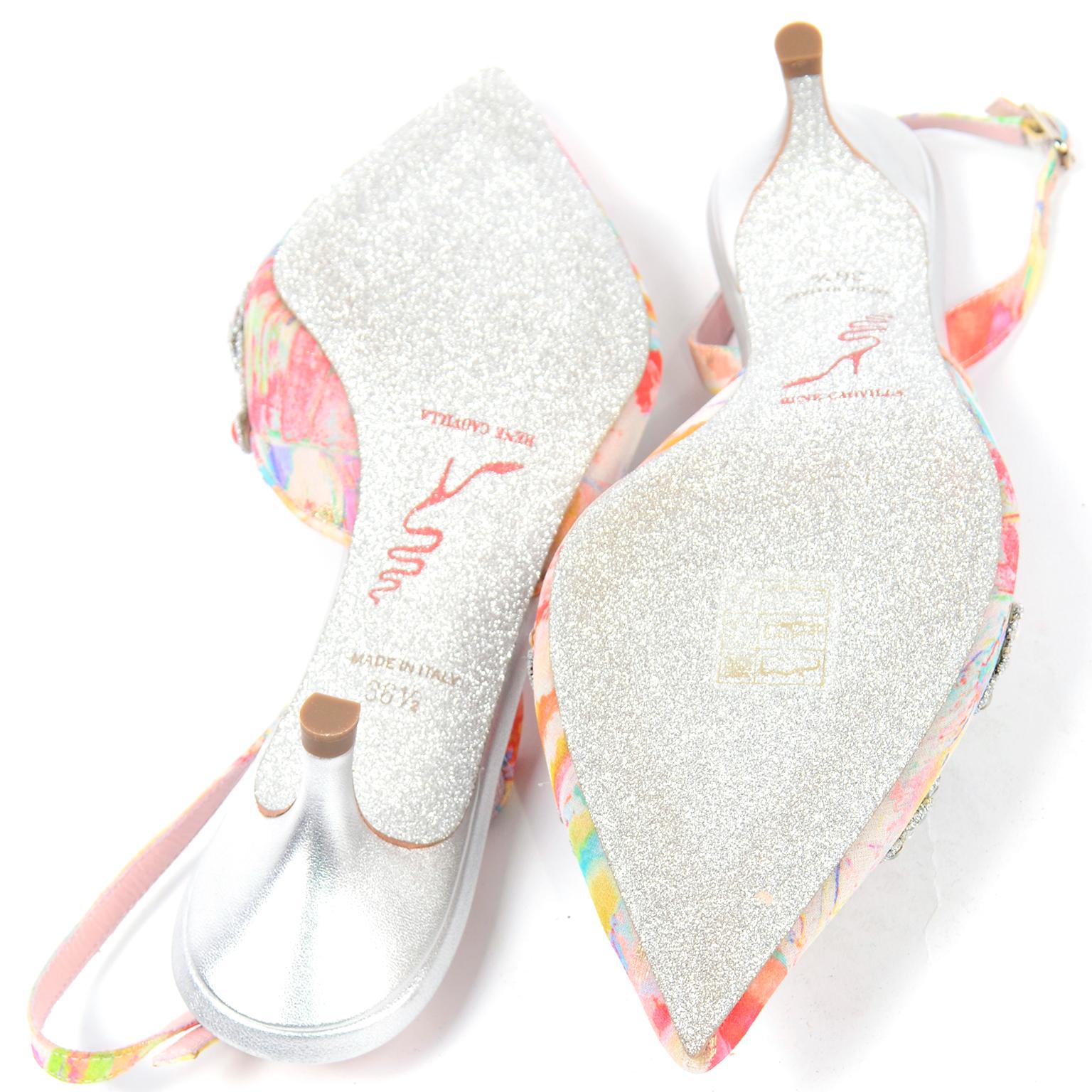 This is a sparkling pair of unworn Rene Caovilla slingback shoes in a pink and yellow floral with multi colored jewels on the toe box. Made of fabric and lambskin leather, these shoes are so magical with their silver sparkle glitter soles and on top