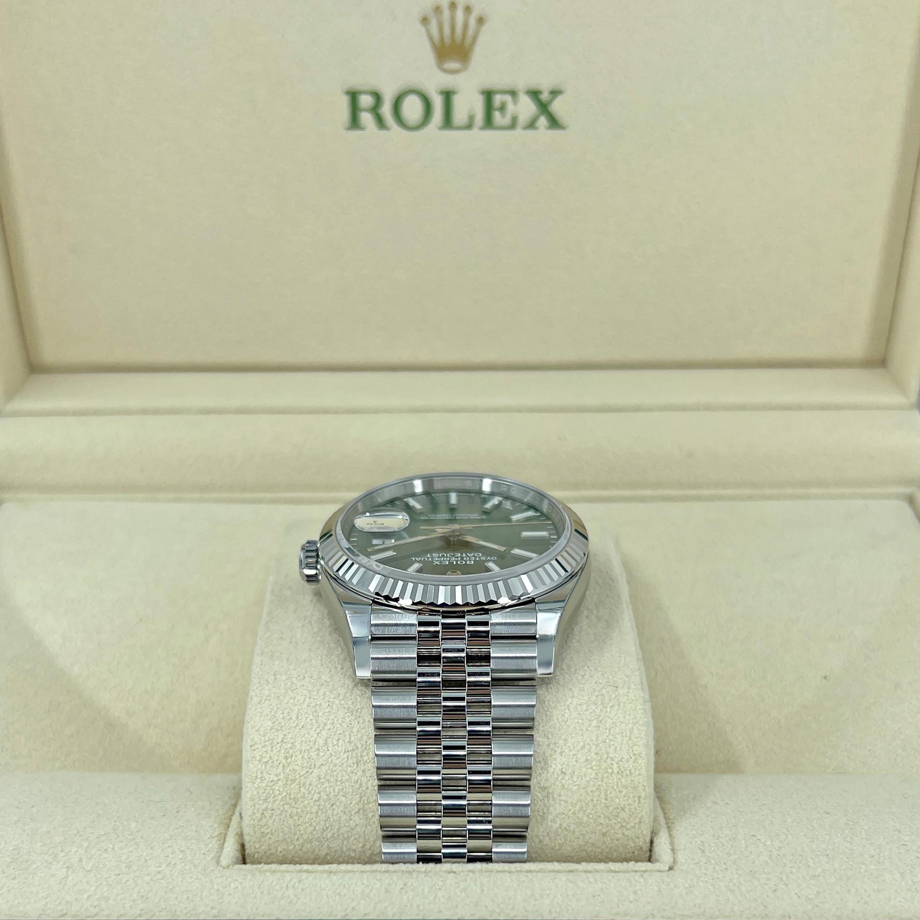 Die Rolex Datejust 36 Ref. 126234-0051 ist eine Meisterklasse in zeitloser Eleganz, die klassisches Design mit zeitgenössischem Flair verbindet. Ihr herausragendes Merkmal ist das mintgrüne Zifferblatt mit Sonnenschliff, ein frischer und