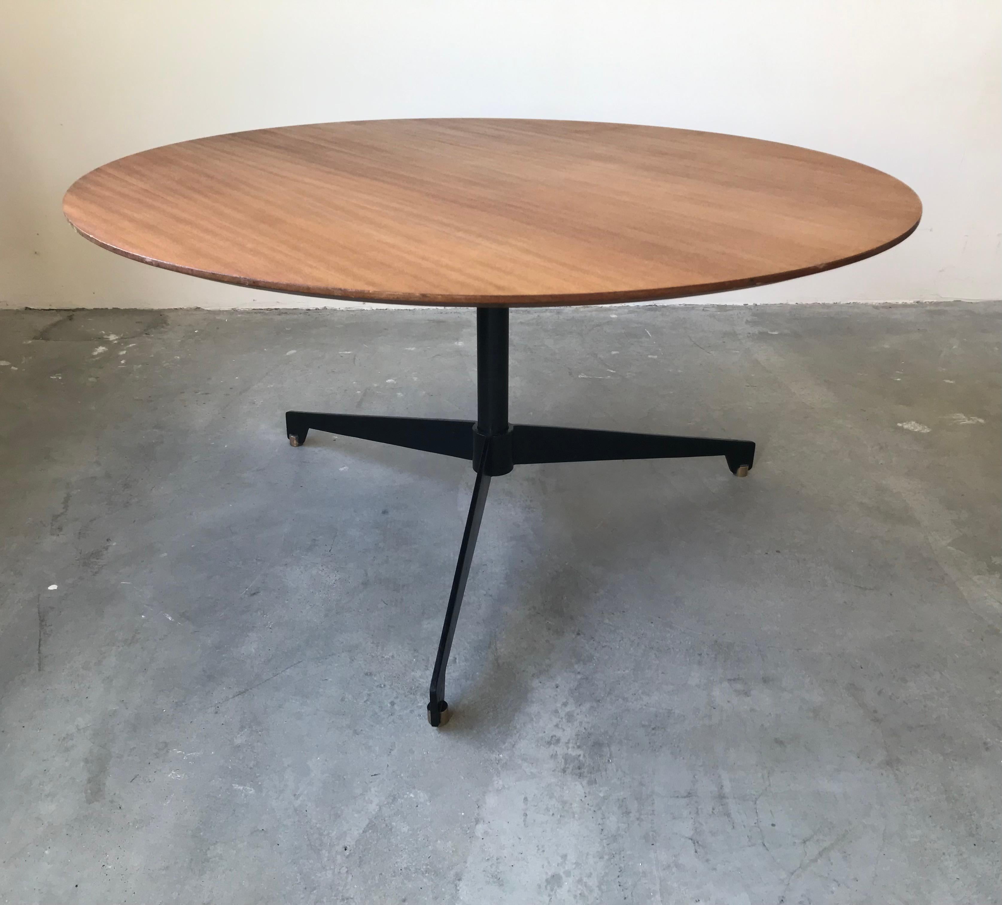 Up and down table attributed to osvaldo borsani, tecno edition, circa 1960. Round teak top resting on a tripod base in black lacquered metal, brass tips. Height adjustable using a handle attached to the foot, it will serve as a dining table with a