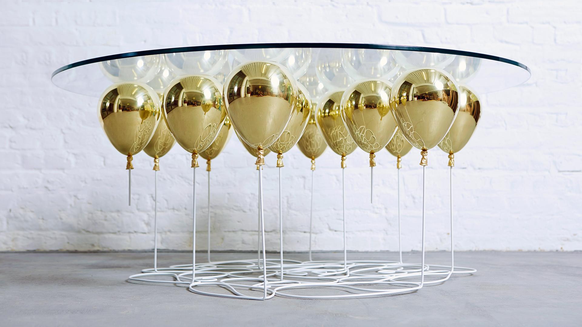 Der UP Ballon Couchtisch ist ein verspieltes Trompe L'Oeil Möbelstück. Eine Reihe schimmernder, polierter Metallballons erweckt die Illusion einer schwebenden Glastischplatte.

Ein faszinierendes Möbelstück, das mit den Konzepten des Schwebens und