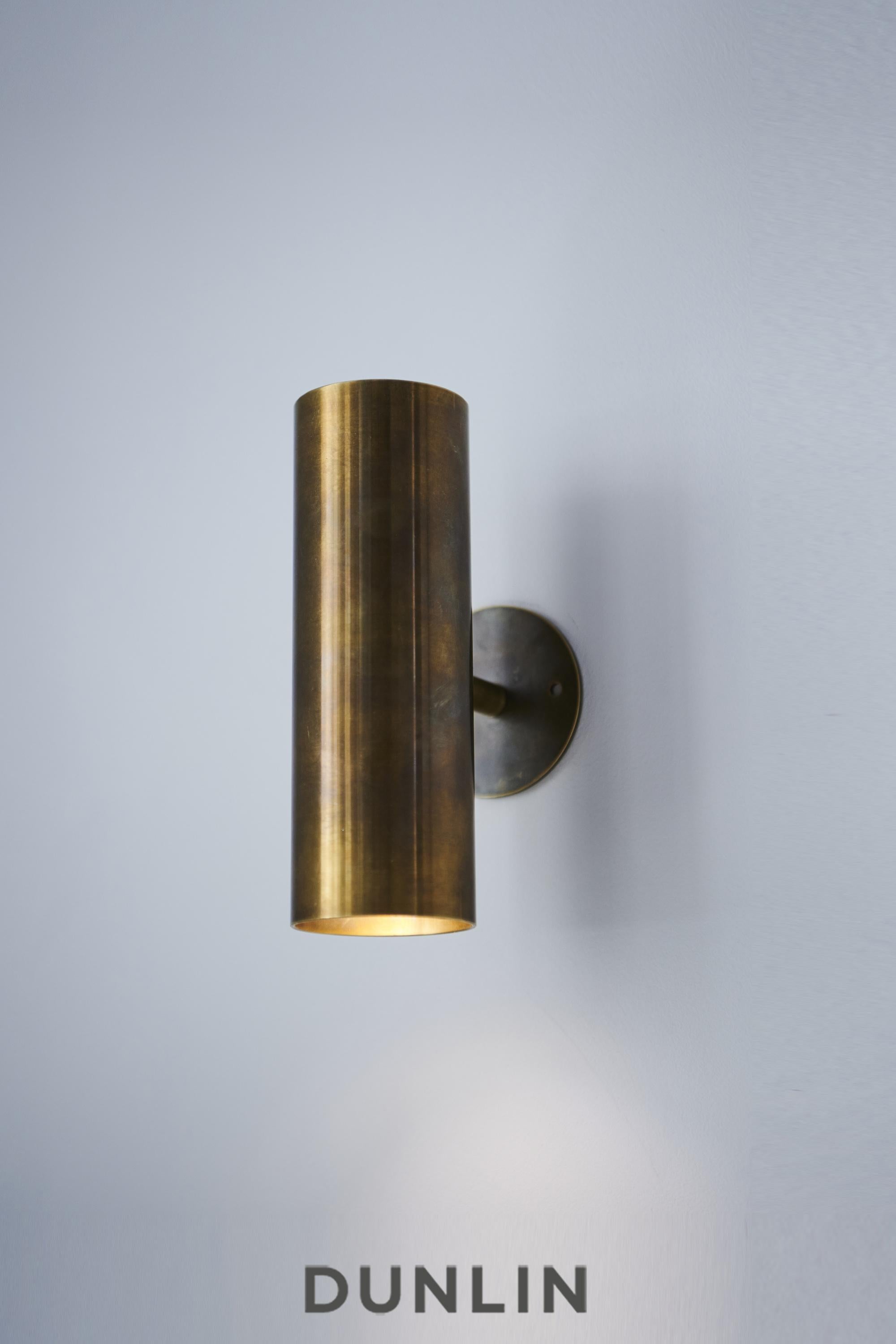 Handmade in solid brass in Sydney, Australia by Dunlin. 

A playful up-down light in solid brass.
Measures: 6.3 cm Diameter x 22 cm Long
Finish: Tarnished Raw Brass
Two lamp holders direct light vertically up and down, or sideways if installed