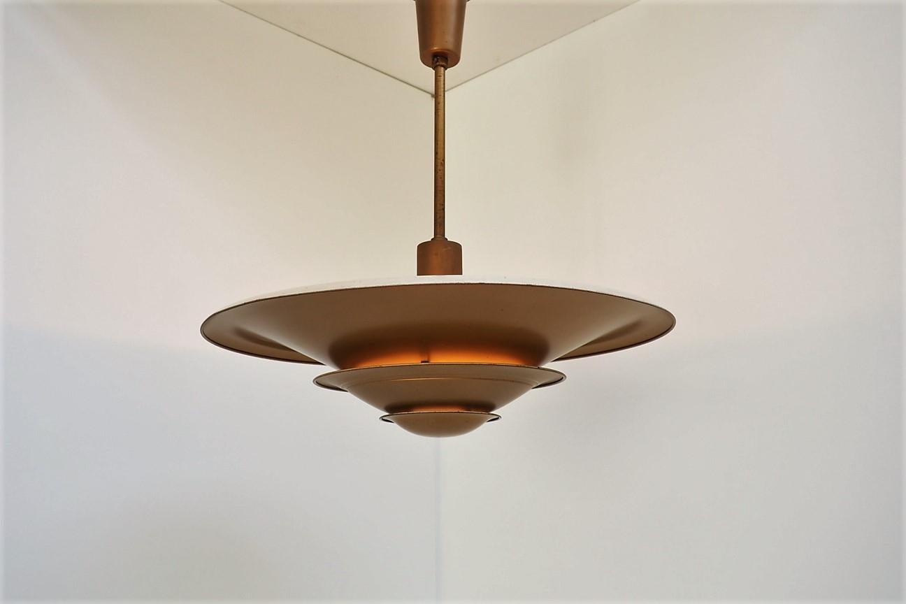 Rare up-light pendant manufactured by Louis Poulsen called A-loftlampe and made in the 1930s.

The pendant is made in solid copper on the outside painted gold and white on the inside, which ensures a good and bright up-light illumination.

The