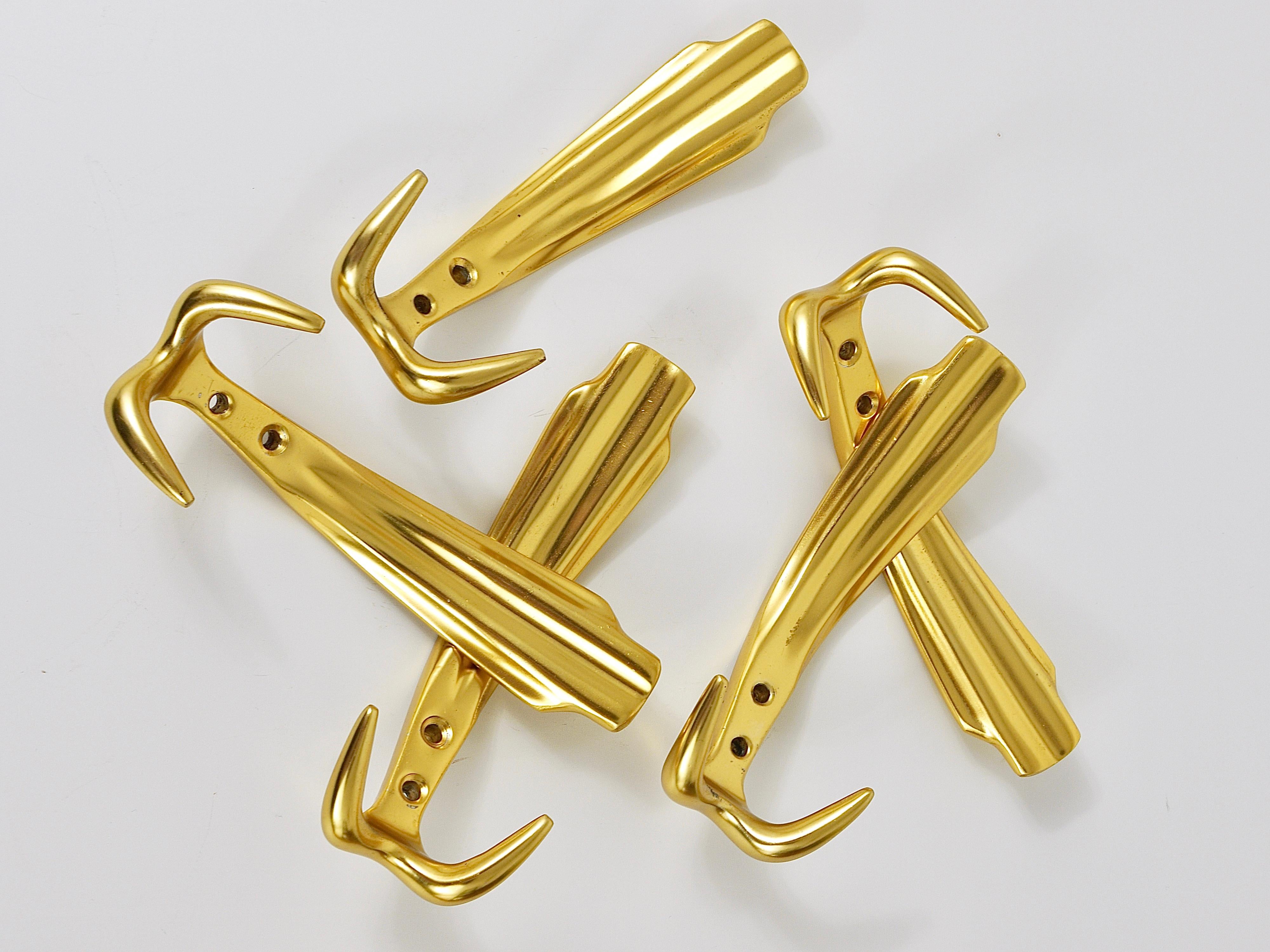 Up to five beautiful and decorative golden Hollywood Regency wall hooks from the 1970s. Made of golden anodized aluminum. The hooks are in good condition with marginal patina. Five hooks are available, sold and priced per piece. Please notice, that