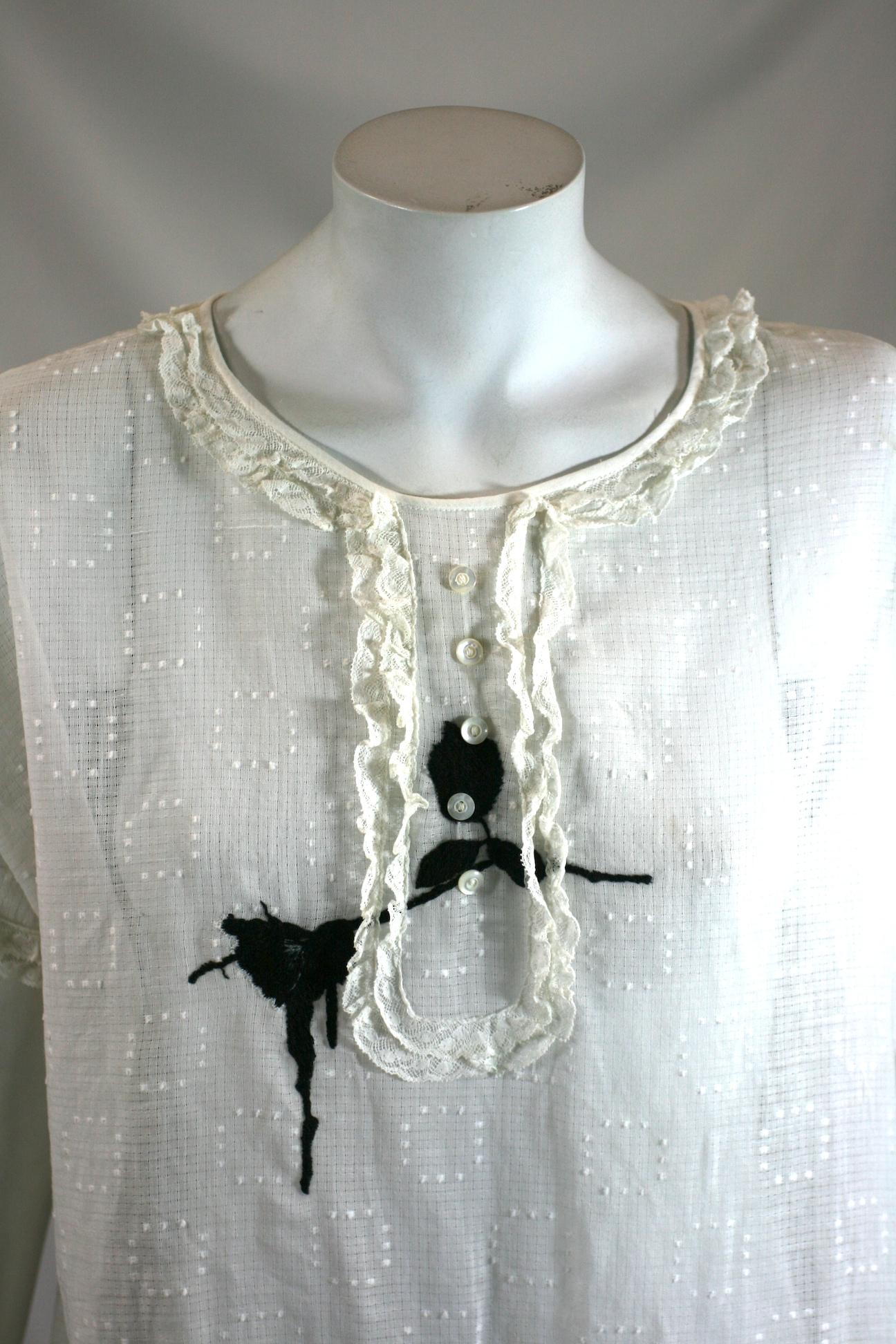 Upcycled Embroidered 1920's Batiste blouse by Studio VL. Period 1920's sheer cotton batiste swiss dot blouse with lace ruffle trim throughout. We have embroidered a silhouetted black rose through the center across the heart. 
Beautifully hand
