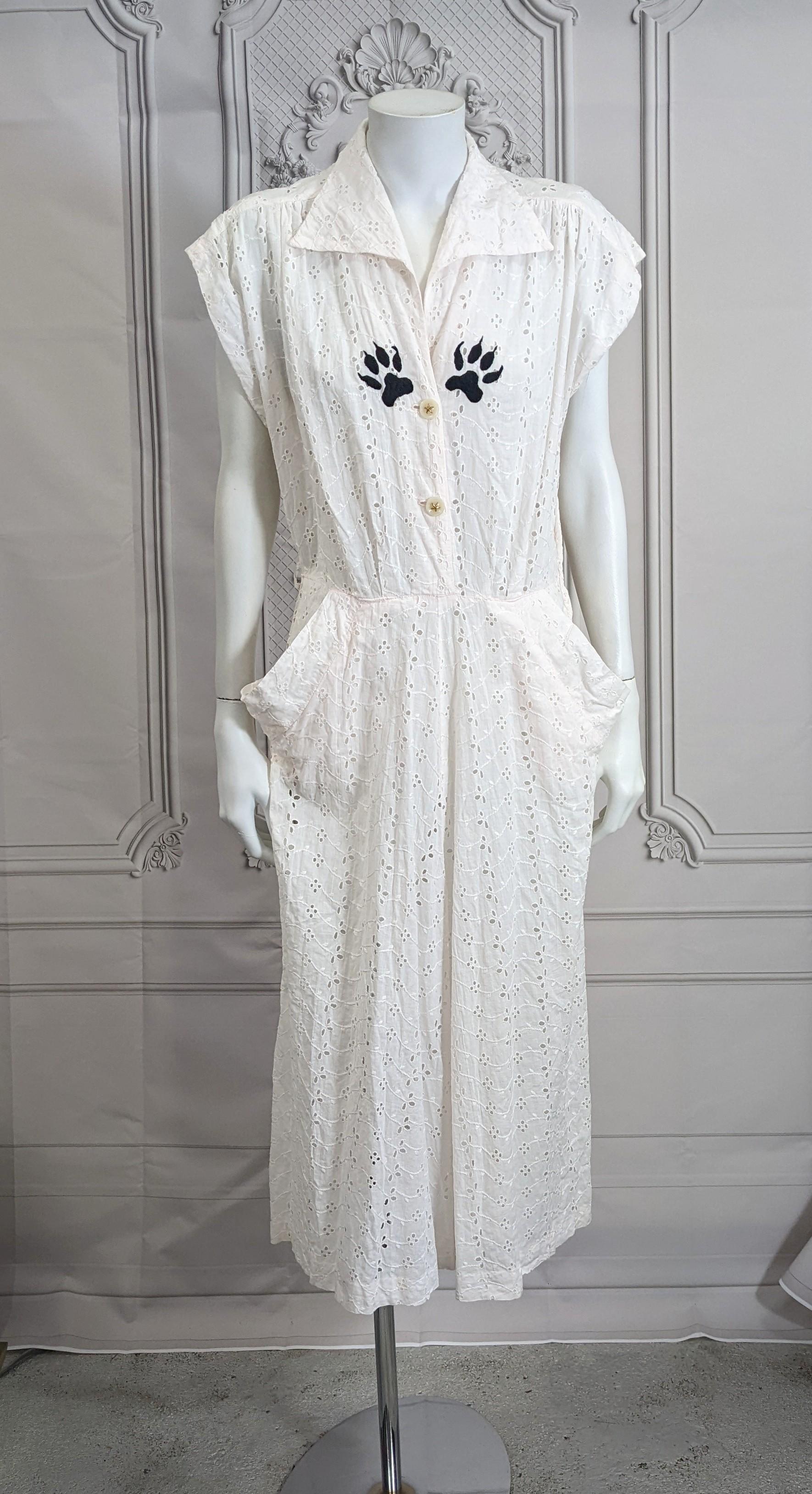 Upcycled Eyelet Dress with Hand Embroidery, Studio VL. Easy 1950's cotton eyelet shirt waist dress with front buttons and side zipper with a slightly pink tint. 
We have embroidered 2 naughty cat paws on the chest in black, based off rapper Eves'