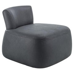 Sillón tapizado con un distintivo respaldo de madera maciza