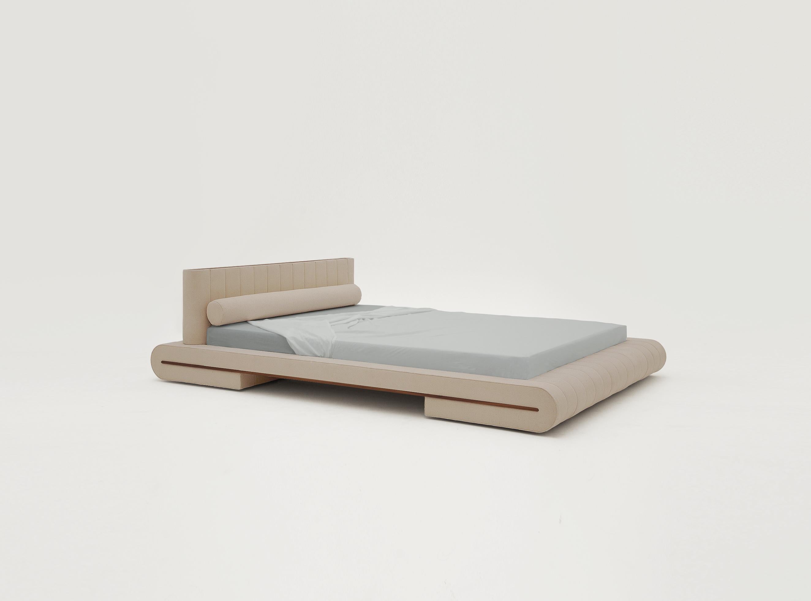 Docked en Rio has a fully upholstered bed frame. The cotton weave is stretched around a folded mattress frame inspired by traditional Japanese furniture. The form is composed of modular cross-sections with a walnut rail that accentuates the folding