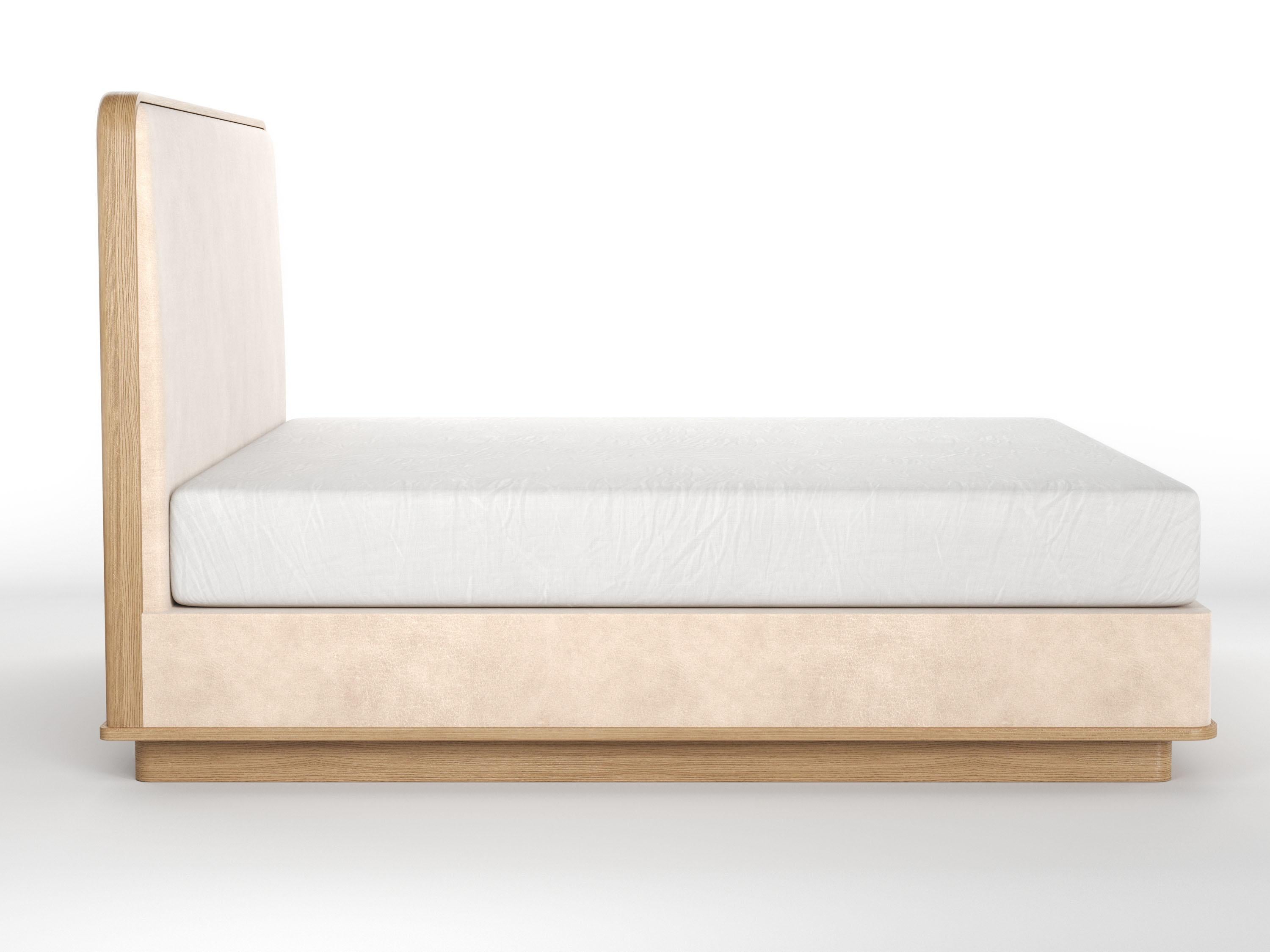 The Cooper bed shown with plain covered headboard panel clad with wood trim - with self covered rails and sitting on wood platform and recessed wood base. All hand made in our shop in Brooklyn, New York by our artisans. This item is only made custom
