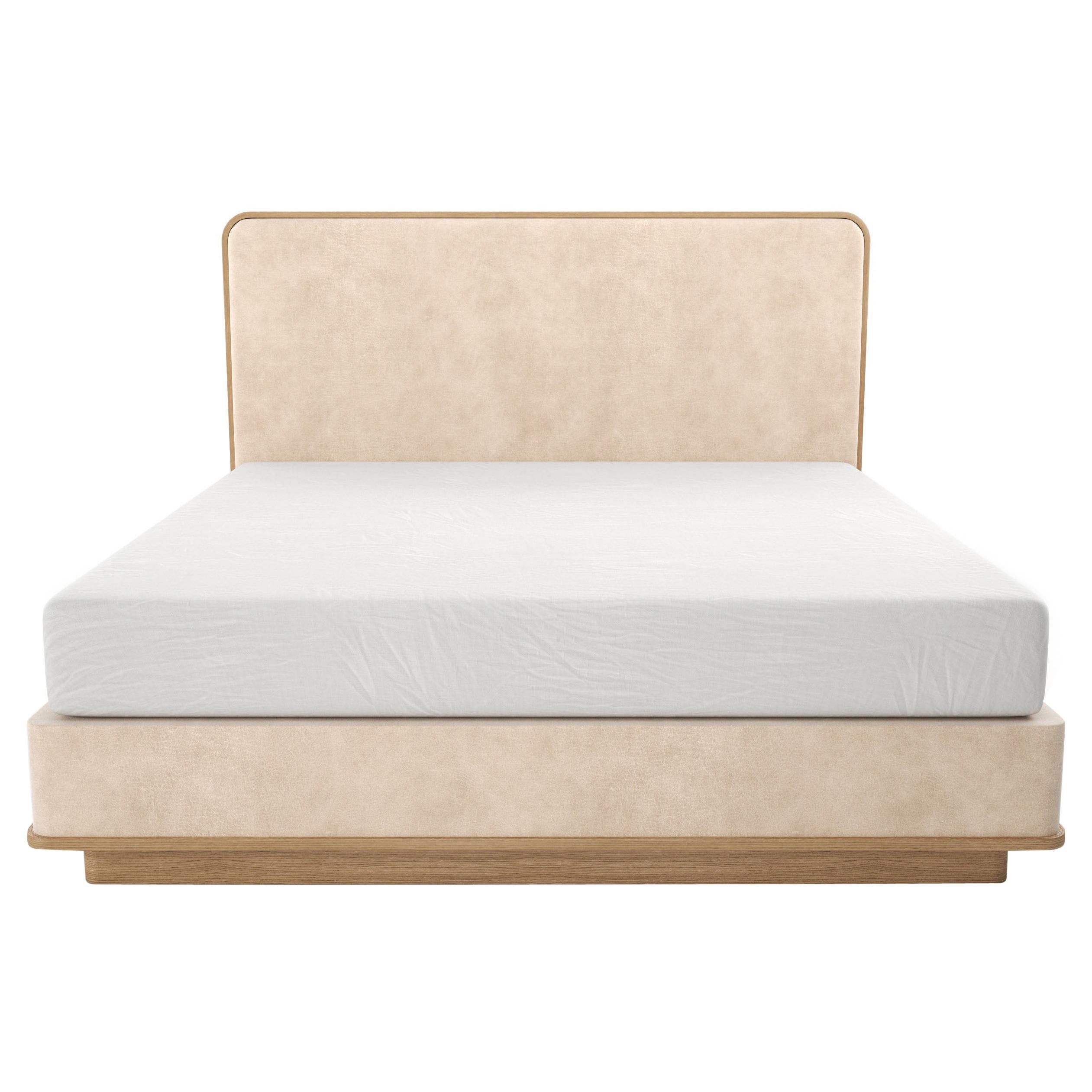 Gepolstertes Bett mit abgerundetem, abgedecktem Kopfteil auf geschnitzter Holzplatte und Sockel  im Angebot