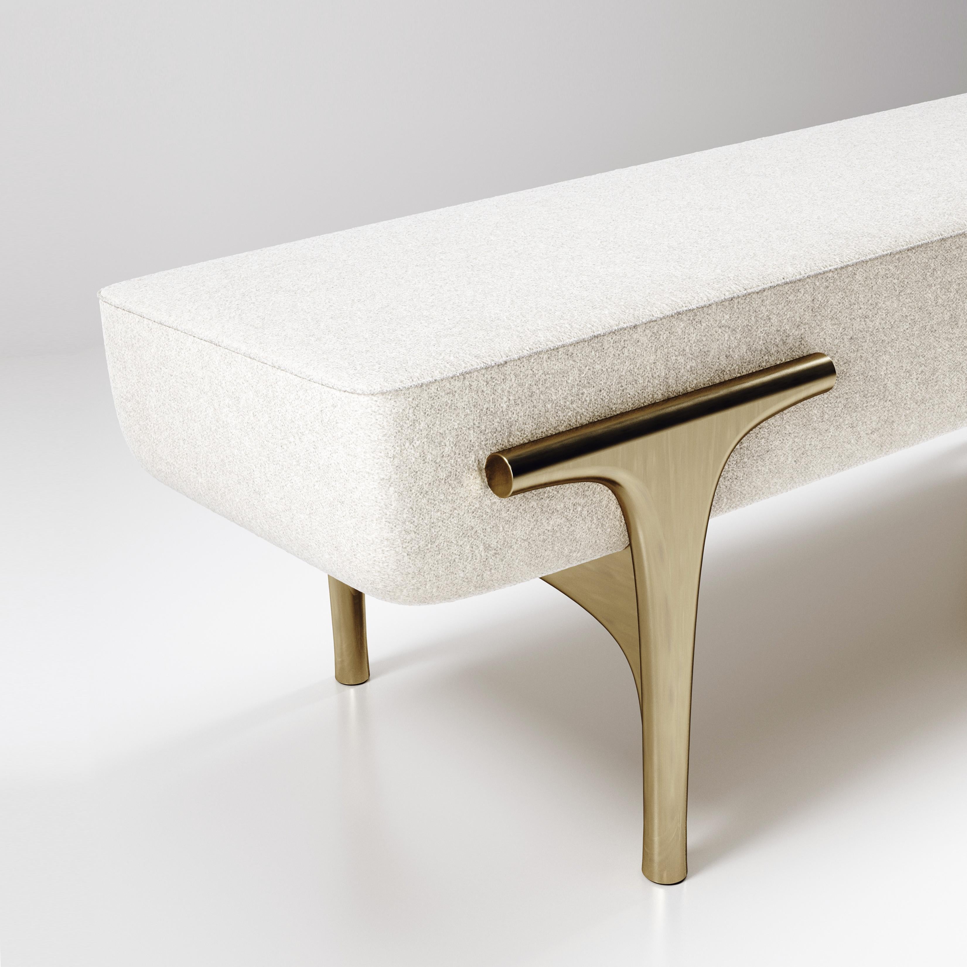 The Ramo bench by R & Y Augousti is an elegant and versatile piece. The upholstered piece provides comfort while retaining a unique aesthetic with the bronze-patina brass frame and details. The cream fabric is by Pierre Frey. This listing is priced