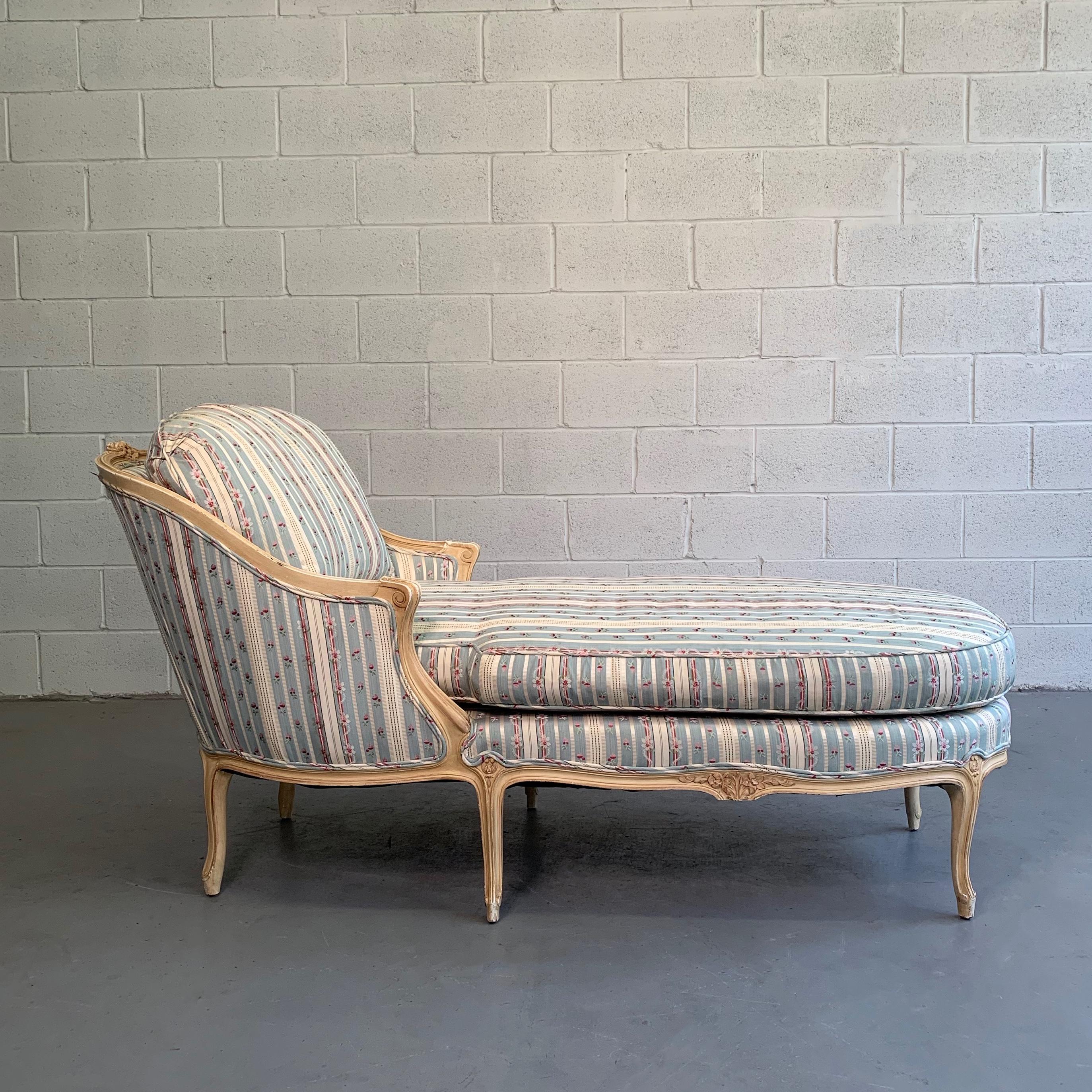 Lovely chaise longue or fainting couch circa 1960s features a carved mahogany frame with striped linen blend upholstery.