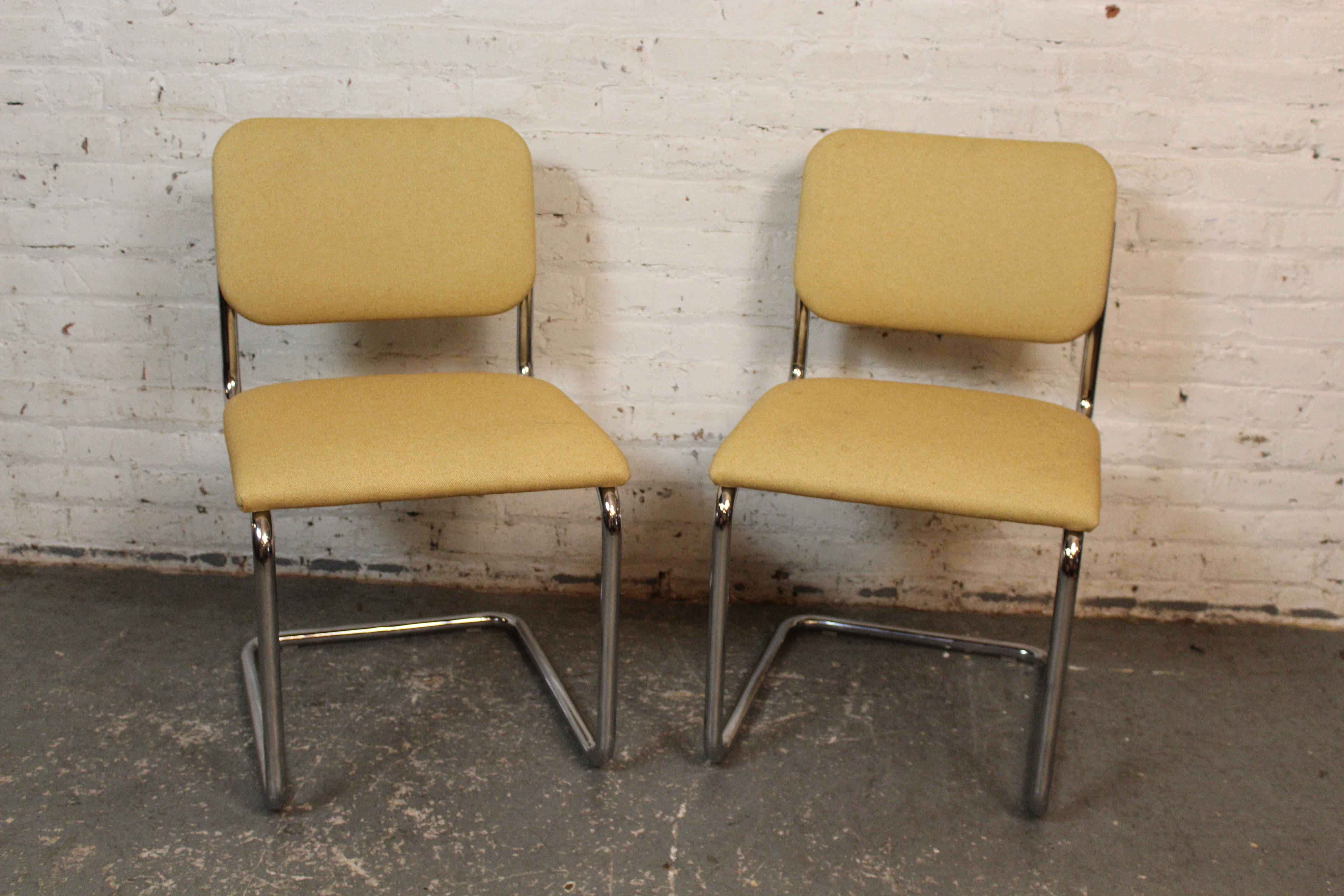 Un clásico par de sillas auxiliares Cesca diseñadas por Marcel Breuer y producidas por Knoll Studio. Estas icónicas sillas en voladizo presentan una estructura tubular de acero cromado con asientos y respaldos tapizados en un tejido beige neutro.
