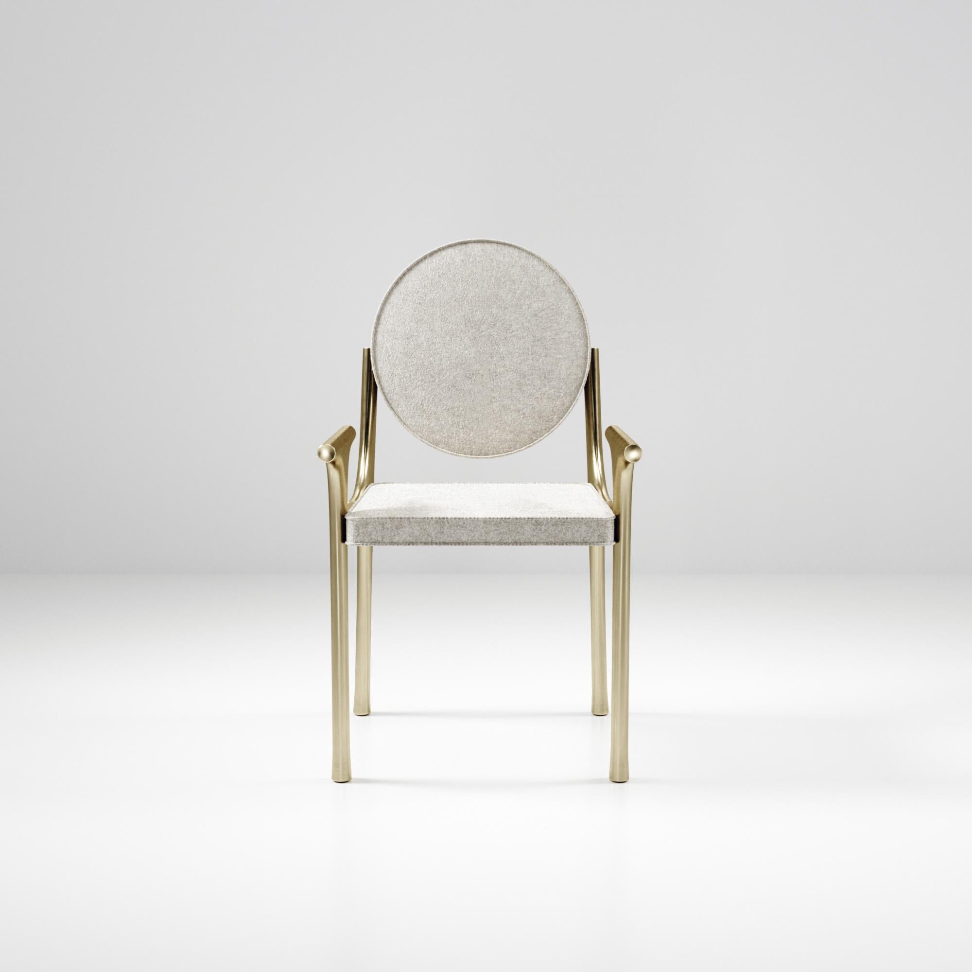 The Ramo chair by R & Y Augousti is an elegant and versatile piece. The upholstered piece provides comfort while retaining a unique aesthetic with the bronze-patina brass frame and details. This listing is priced for COM supply by client, see other