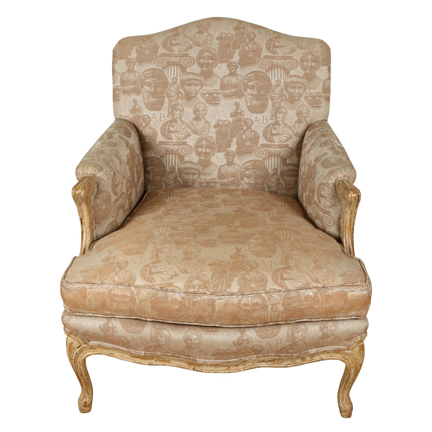 Upholstered damask arm chair and ottoman with visage motif with French style frame and legs. Chair measures 32