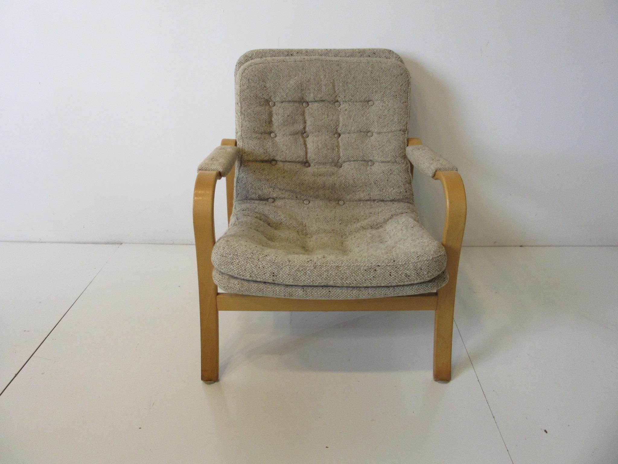 A sculptural birch wood framed lounge chair upholstered in Danish styled woven oatmeal fabric as are the arm pads with button back and seat. A simple design that mixes with any decor from any period, made in Sweden by DUX.