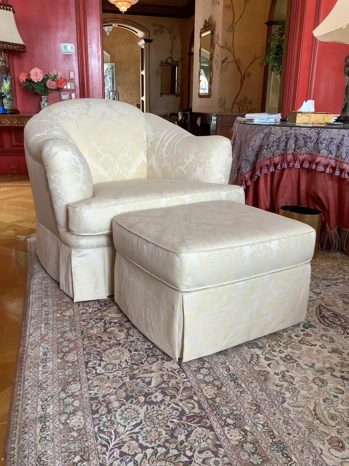 English Scalloped style chair with a serpentine front and upholstered in off white damask with ottoman, 20th Century. Dimensions: Ottoman – 23” D x 16” H x 26” W - Dimensions: Chair - 38” D x 35” H x 41” W.
 