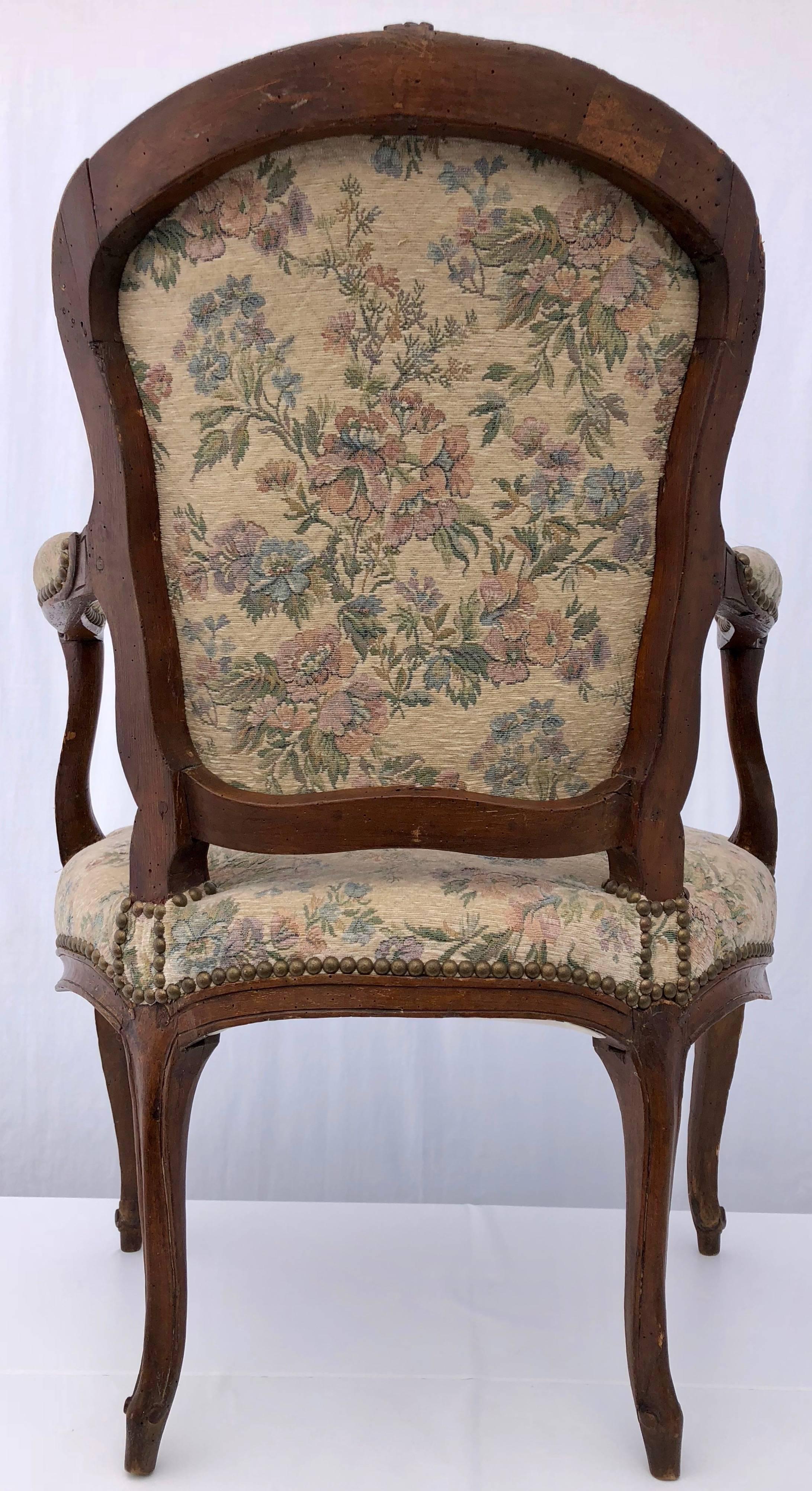 18th Century Upholstered French Bergère Armchair with Hand-Carved Flower on Front, Walnut For Sale