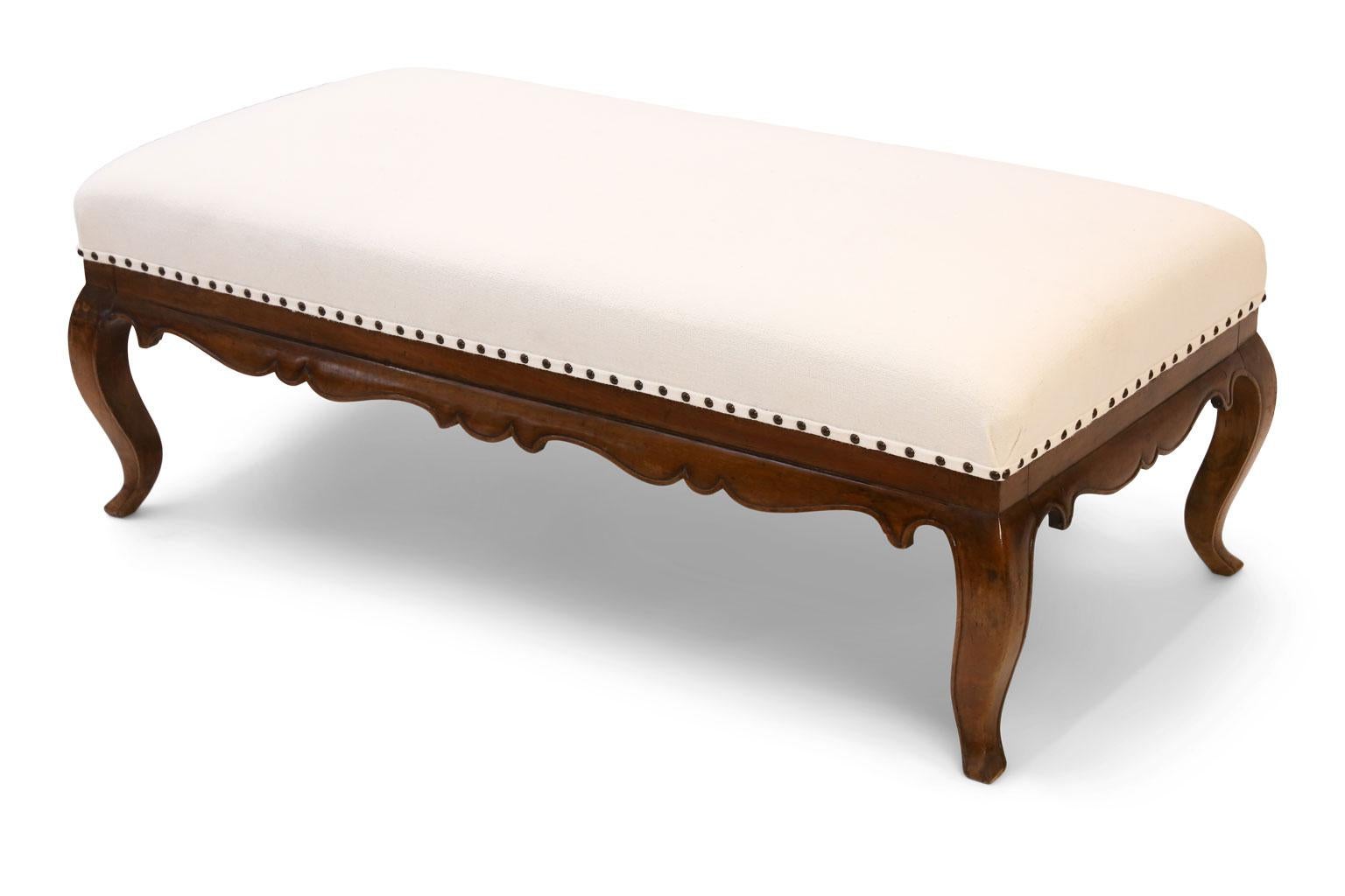 Upholstered French walnut bench in Louis XV style. Nicely carved cabriole legs and shaped apron.