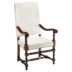 Upholstered Lombardo chair with nailhead detailings. Torsal legs and forearms