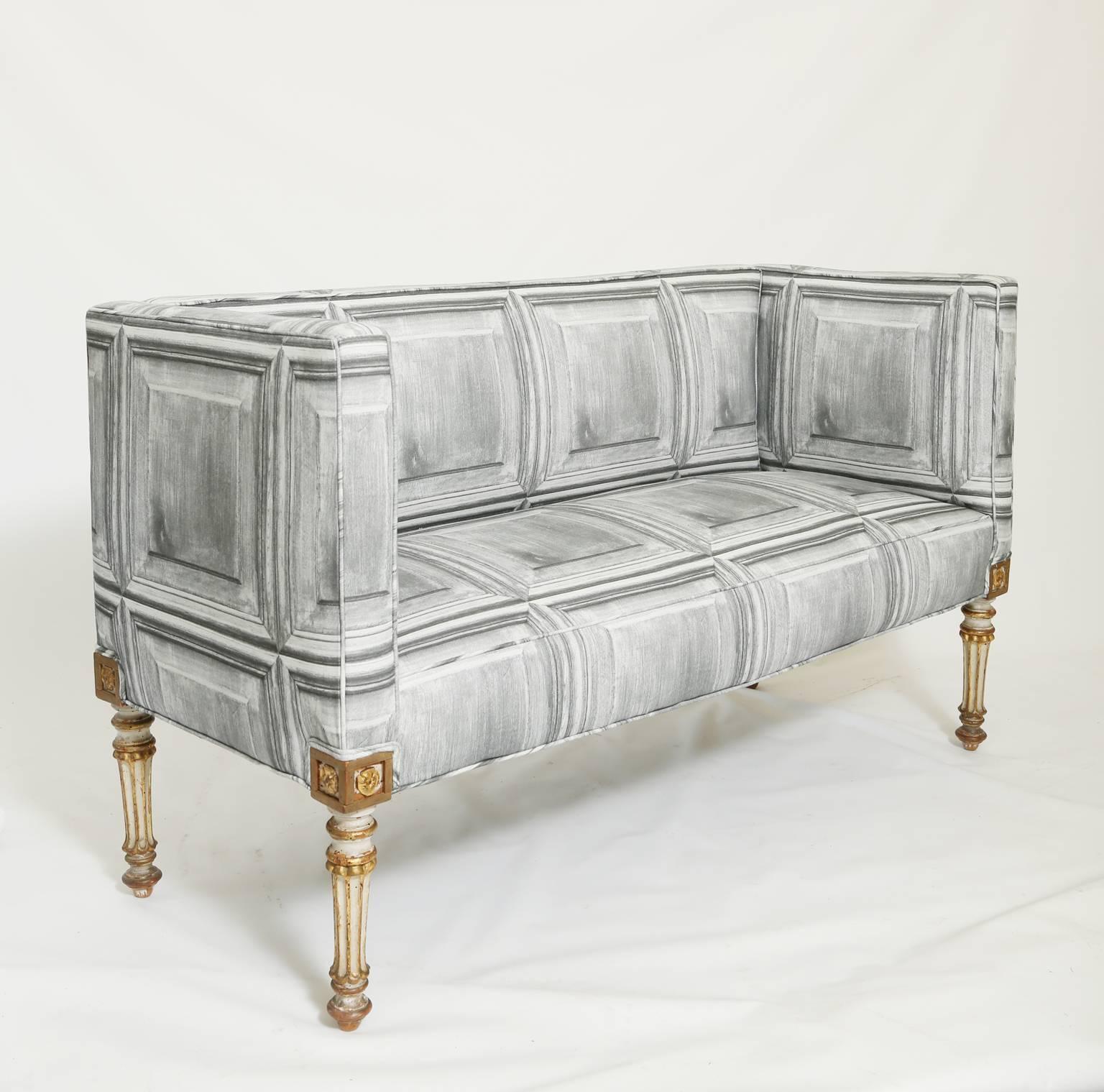 Sofa or settee, having straight padded back and sides, its crown seat raised on rosette-headed, painted and parcel gilt, stop fluted round tapering legs.

Stock ID: D9173