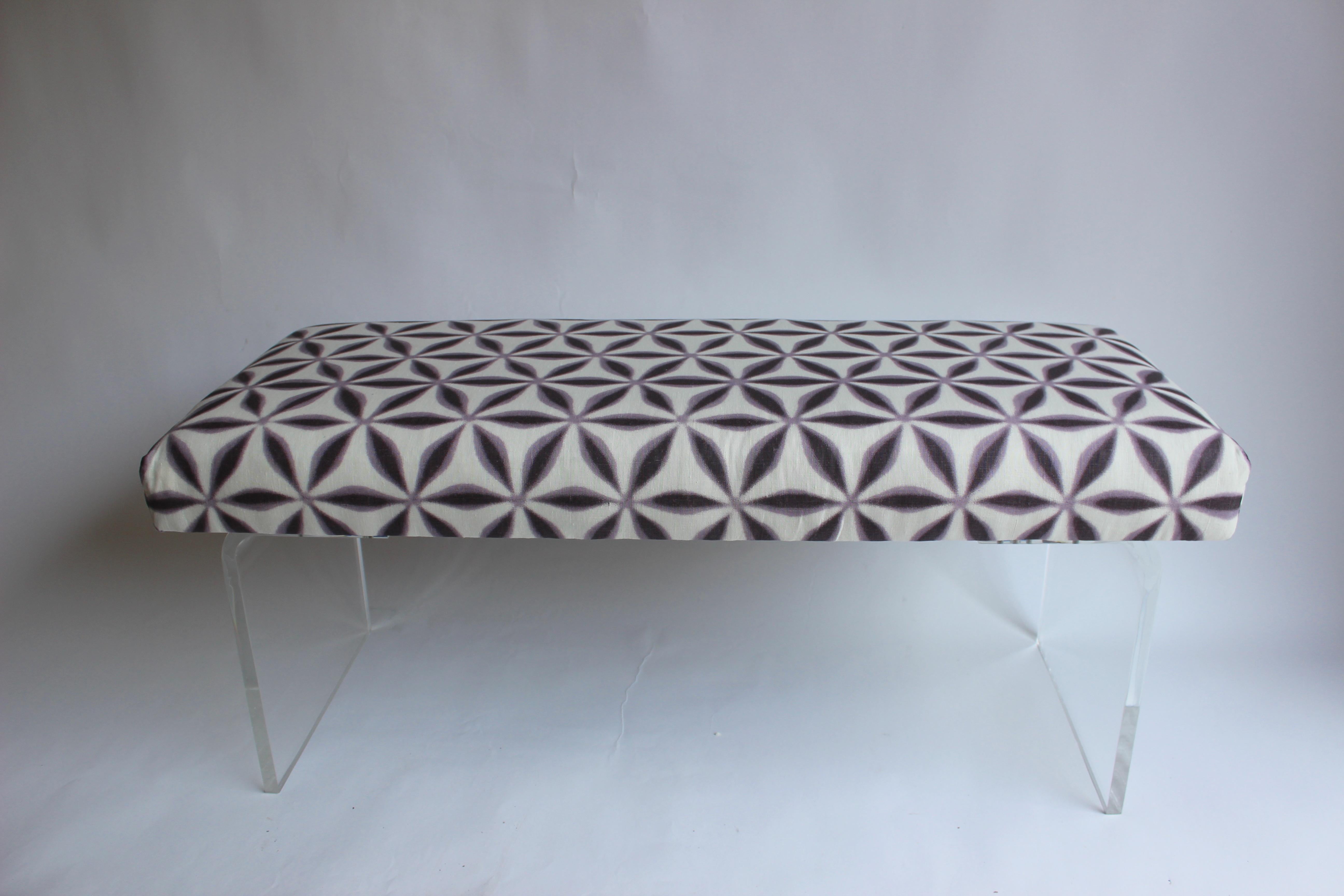 Newly upholstered bench with lucite waterfall legs......fabric is a printed linen from Michael Smith.