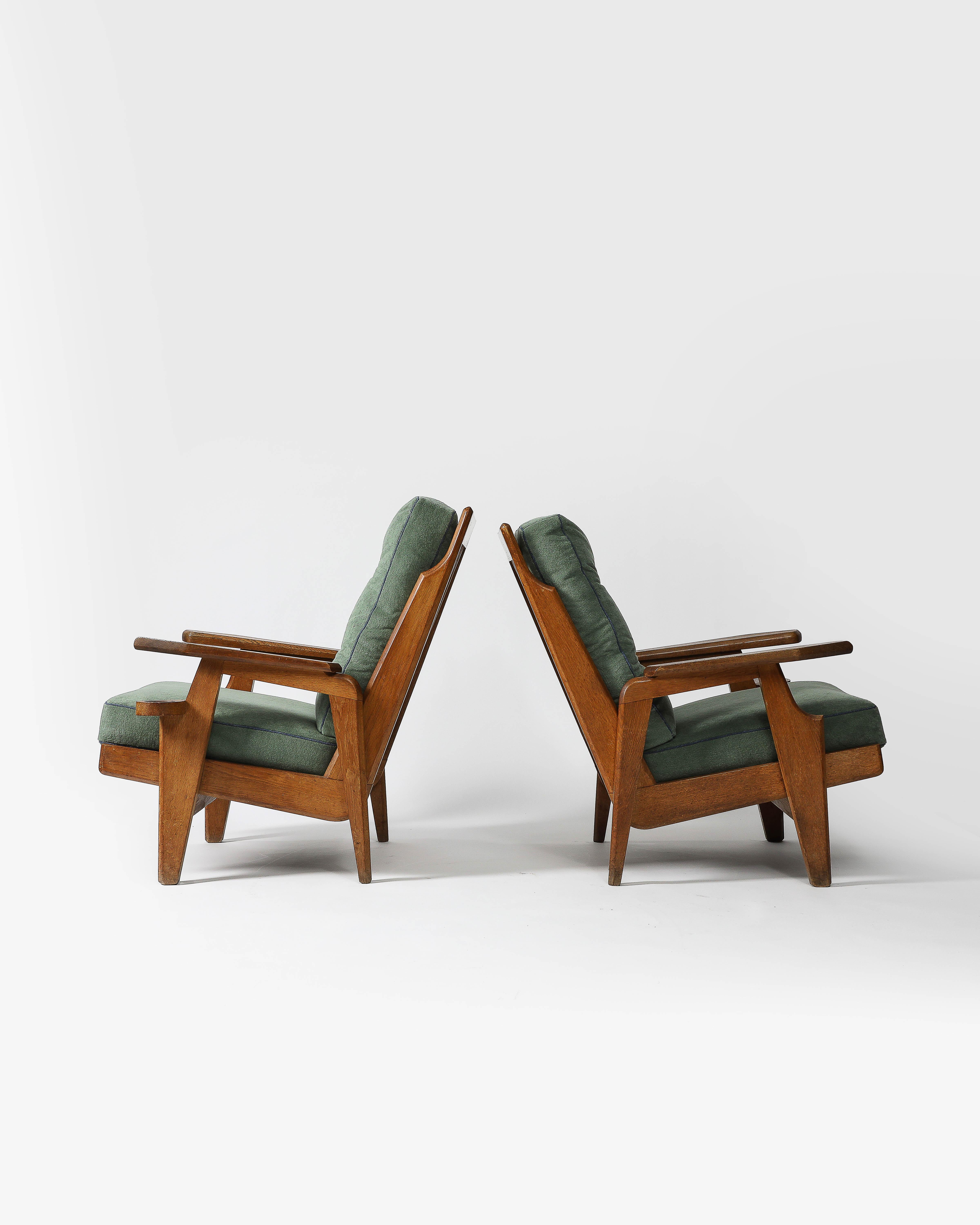 Priced individually; two available.

Sculpted oak lounge chairs by Guillerme et Chambron. These chairs are newly upholstered in Zak + Fox Mosu fabric, with contrast buttons and piping in blue linen.

These armchairs are slightly different