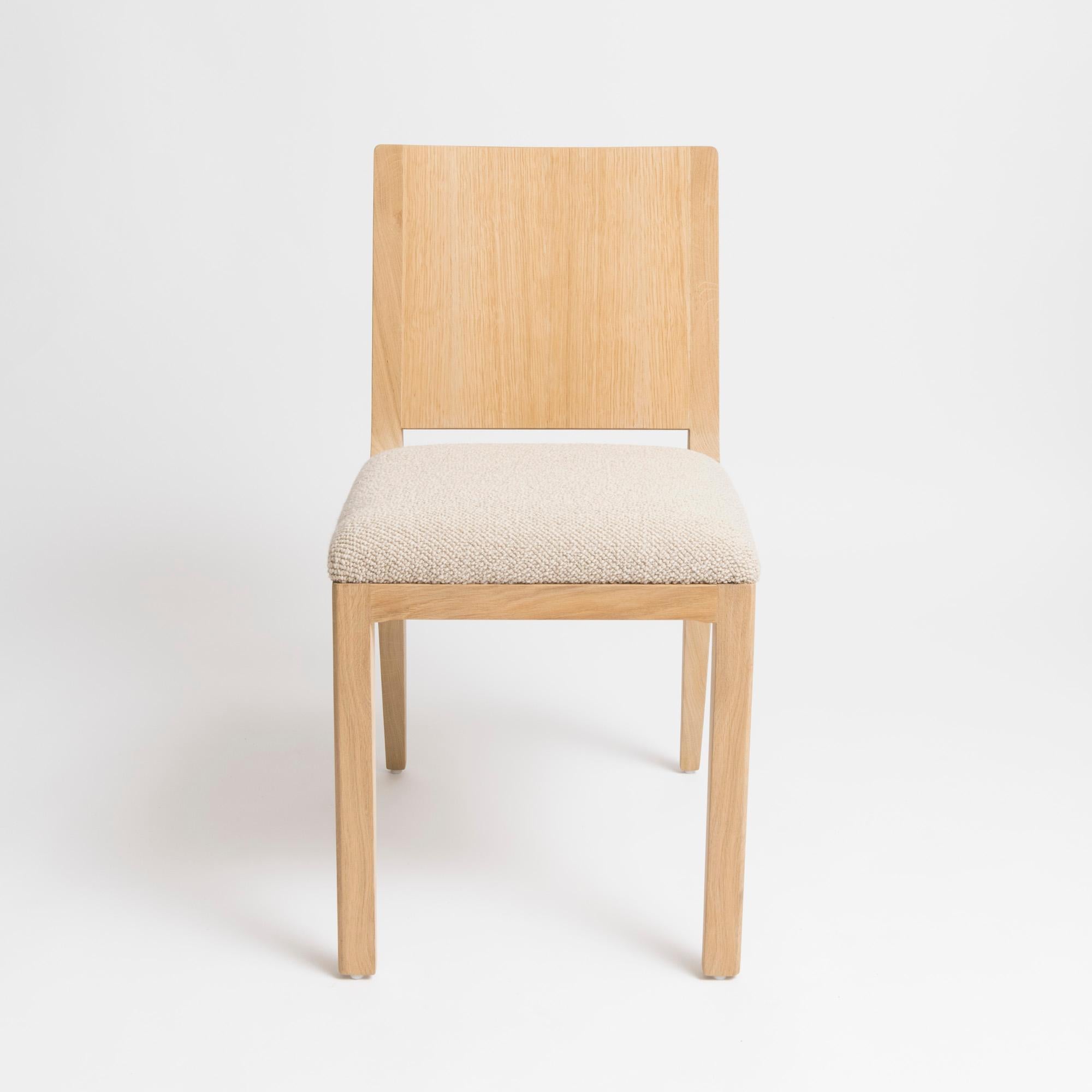Chaise au design moderne et minimaliste du studio parisien mjiila. L'om5.1 est une chaise haut de gamme rembourrée et contemporaine, fabriquée à la main par un ébéniste qualifié. Disponible en chêne français naturel, tapissé d'un tissu 