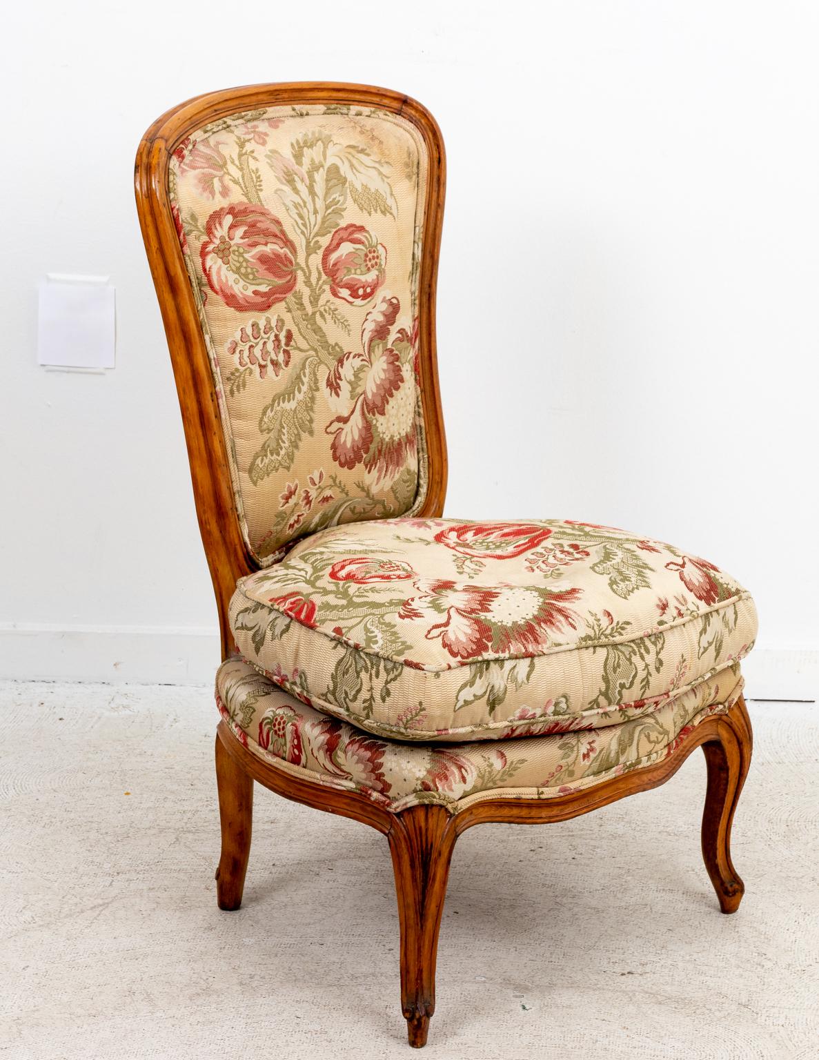 Upholstered slipper chair with quilted floral fabric and cabriole legs. Please note of wear consistent with age.