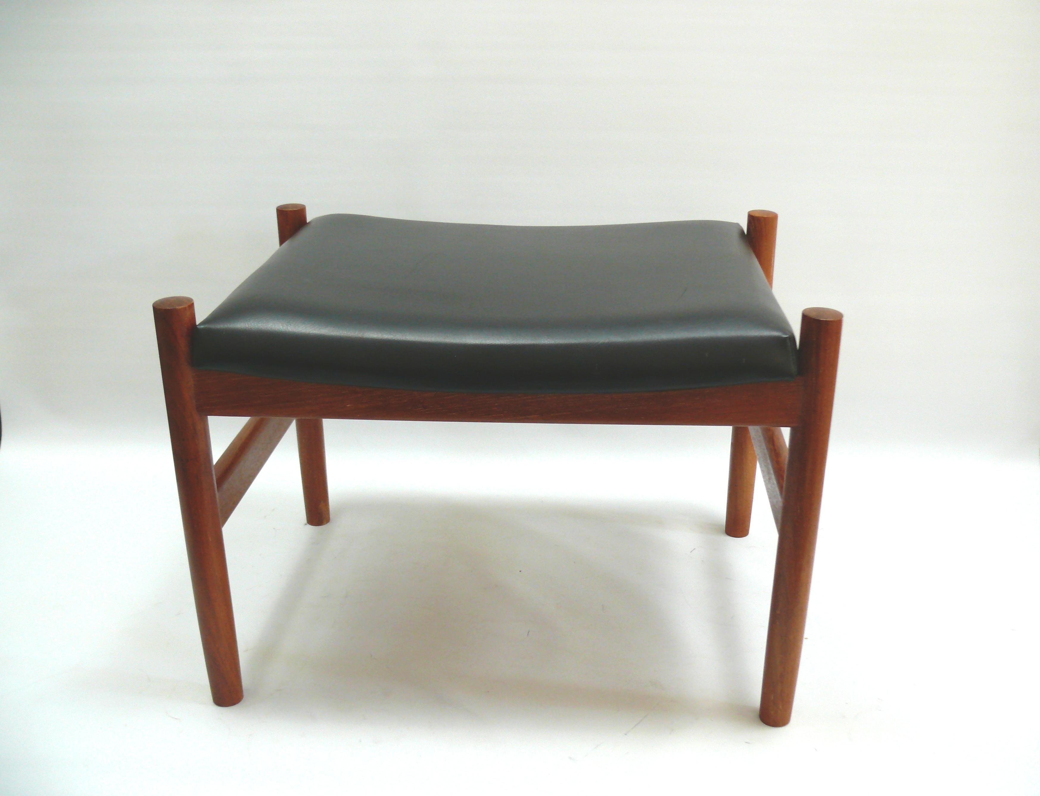 Due pouf/sgabelli in teak identici, disegnati da Hugo Frandsen per Spøttrup Møbler Danimarca negli anni '60, rivestiti in ecopelle nera. Adatto come poggiapiedi per una poltrona o come sgabello. Buone condizioni, con normali segni di usura sulle