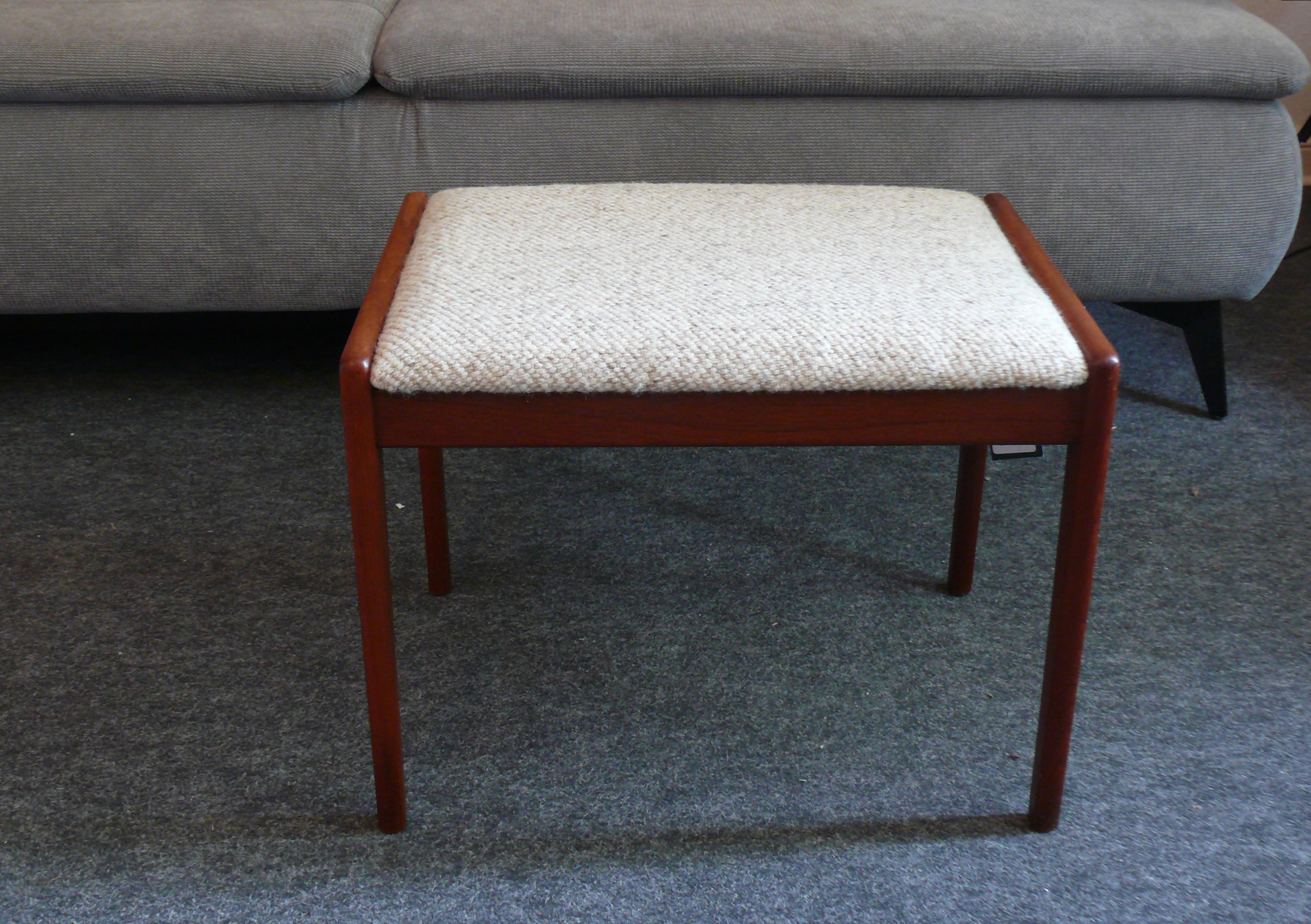 Teak ottoman/stool, designed for KS Møbler Denmark in the 1960s, upholstered in a beige wool fabric. Manufacturer's stamp present. Suitable as a footrest for an armchair or as a stool. The upholstery is in good condition, with only minor wear. A