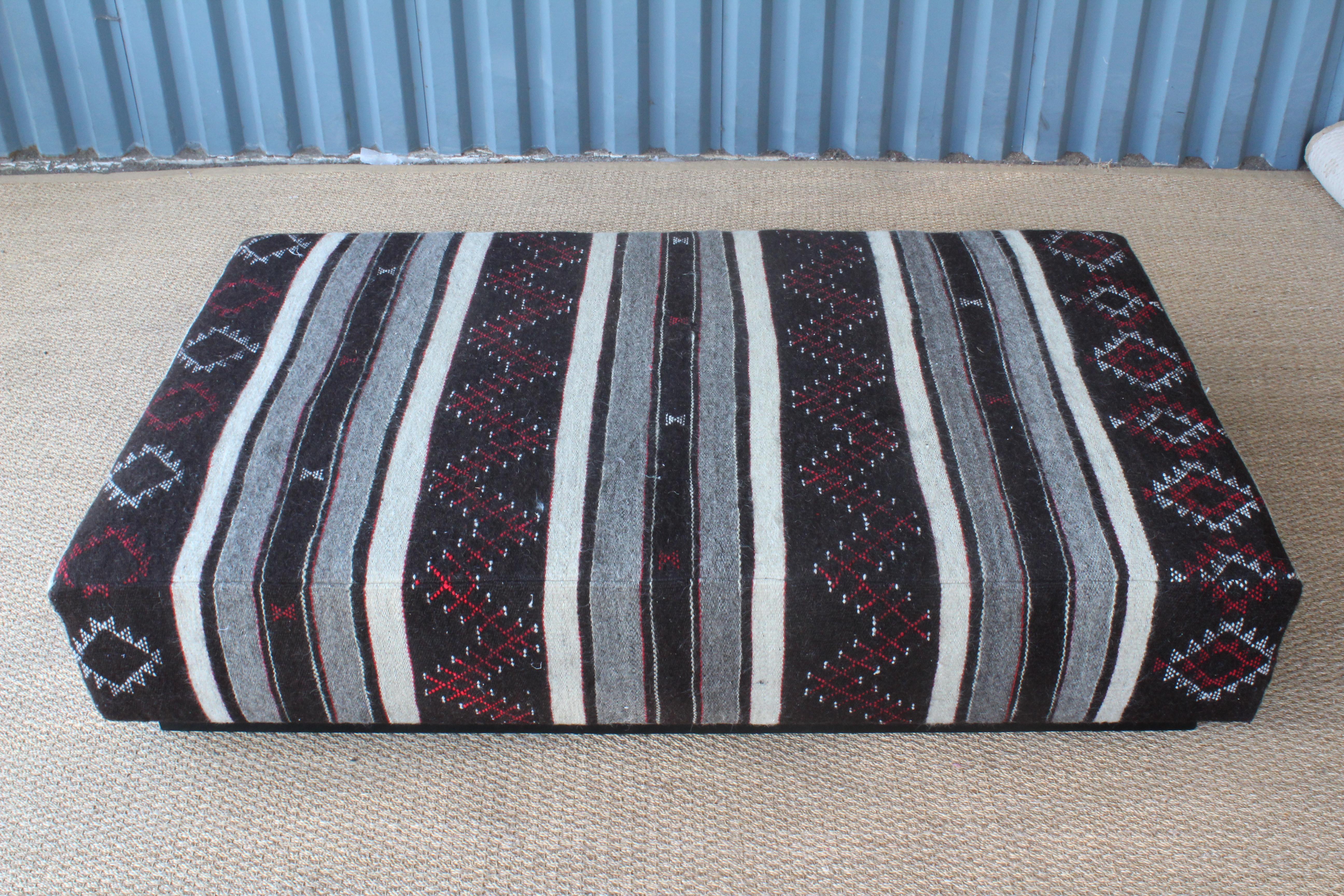 Large custom made ottoman upholstered in a vintage 1960s Turkish flat-weave mohair rug. Rug has been professionally cleaned and is in excellent condition. Sits on an ebonized walnut plinth base.