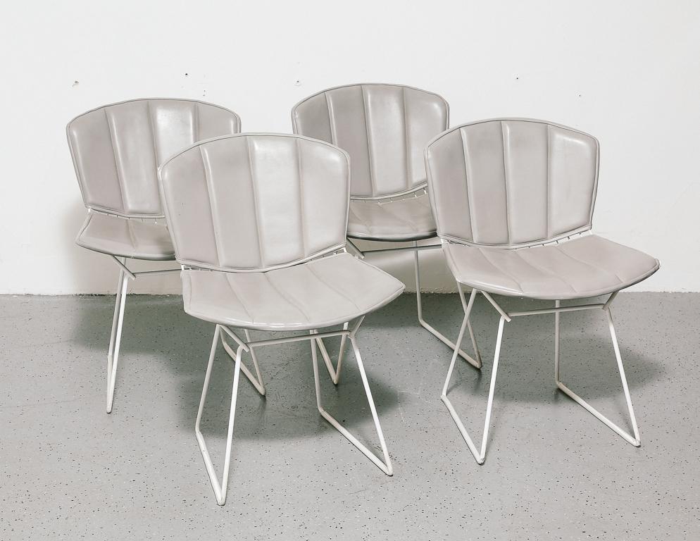 Set of 4 wire dining or side chairs with grey vinyl upholstery. Designed by Harry Bertoia for Knoll.