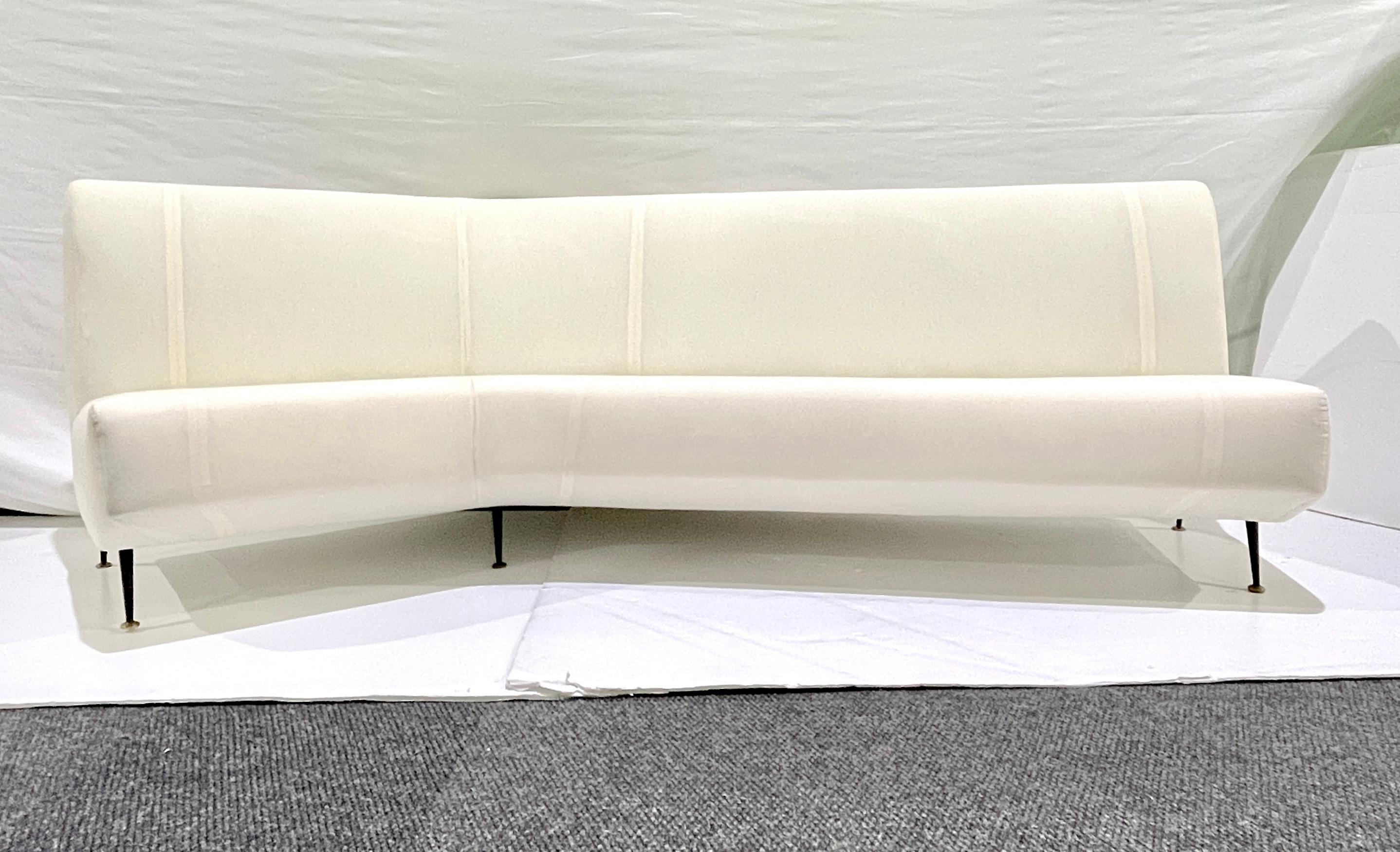 1950s Italian mid-century design in the style of Isa Bergamo, this vintage high back sofa with a curved corner features a sculptural semi-circular silhouette and subtly angled form, gracefully hugging the space around it to offer both visual