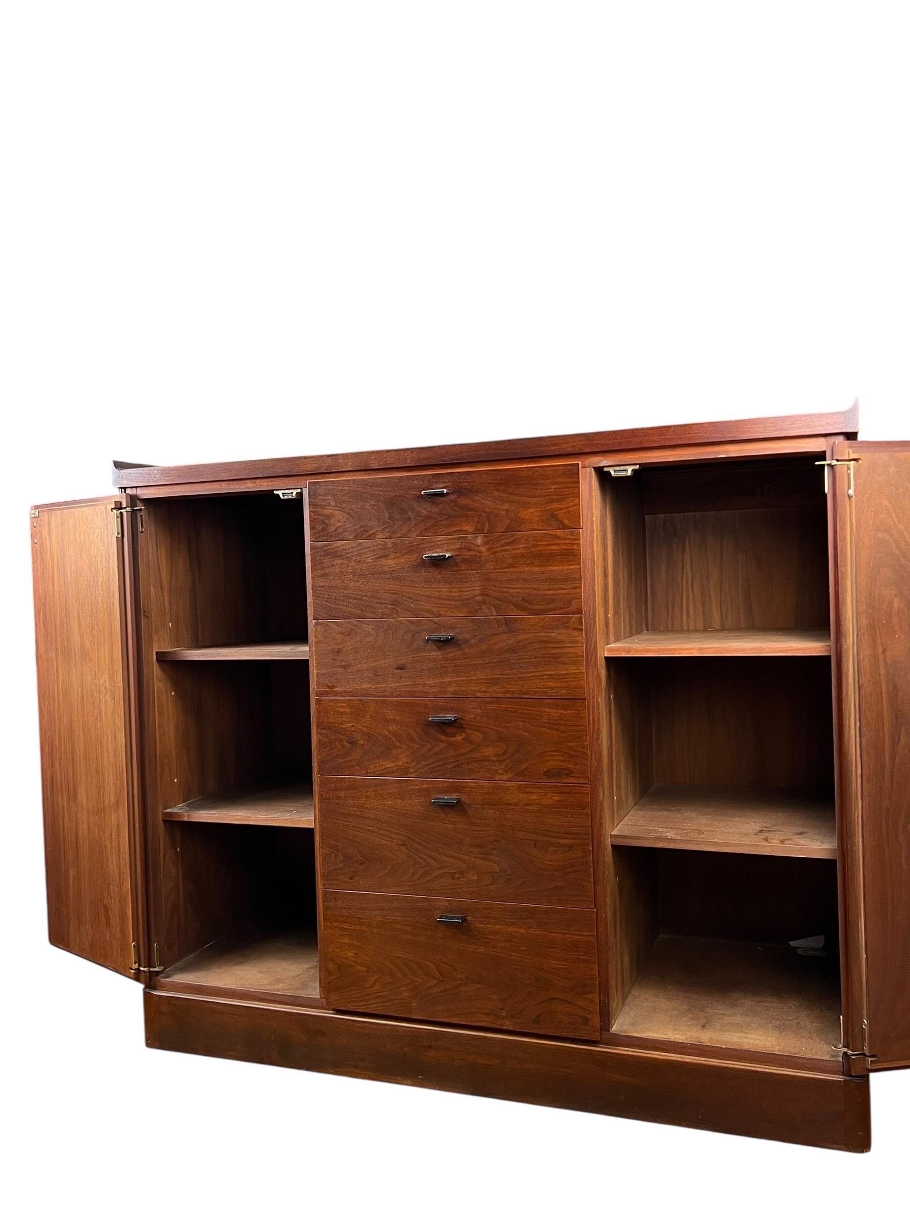 For sale is this unique walnut cabinet made from walnut wood. The cabinet has a door on each side, with two shelves on each side, and six drawers in the middle. The doors are finished with either vinyl or leather.