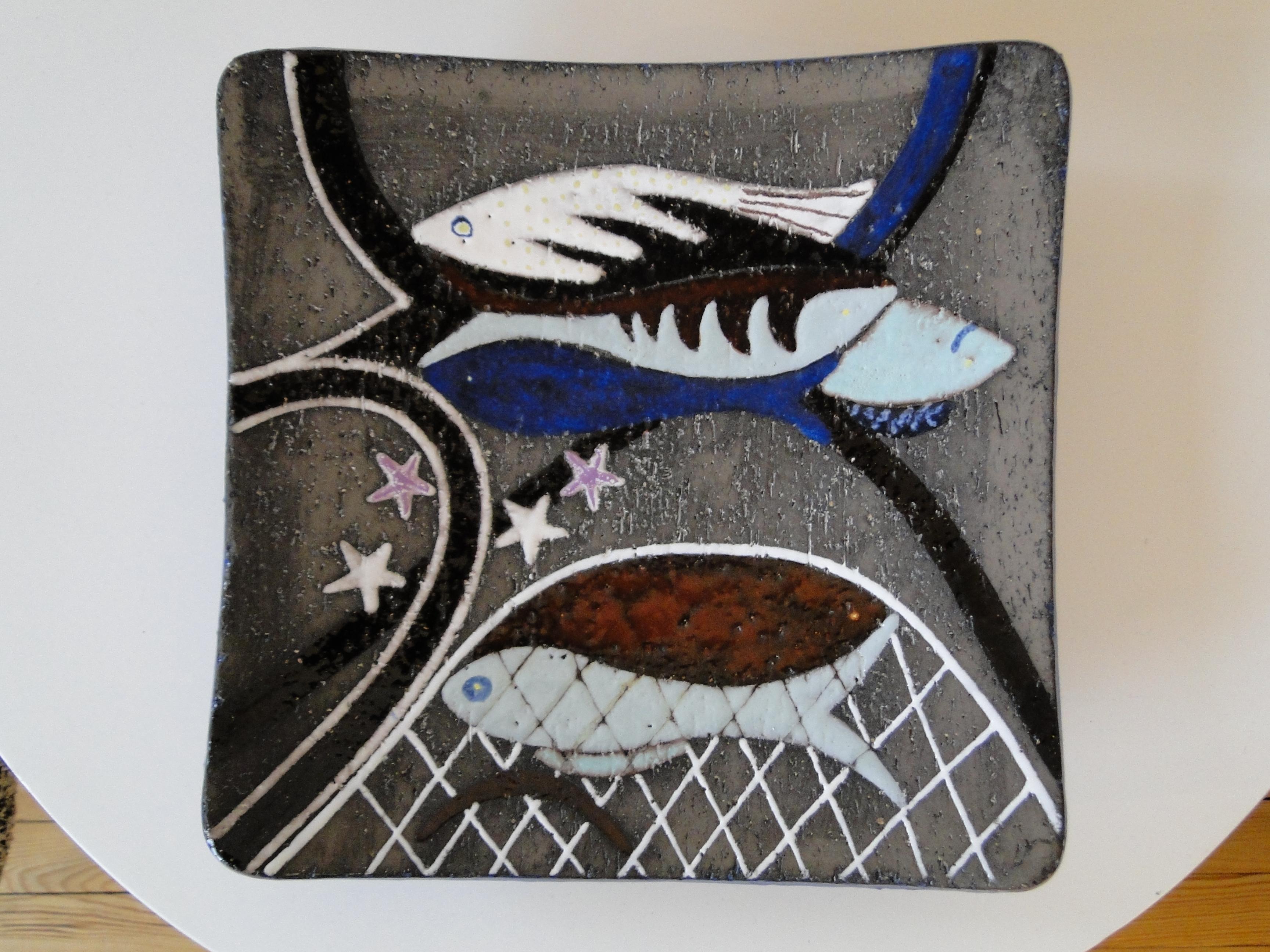 Magnificent dish by Anna-Lisa Thomson for Upsala Ekeby Sweden from the 1960s. 

The dish is in sandstone, the fish enamelled which gives a very nice contrast.

The overseas blue tone enhances this luminous dish that you can hang on the wall or