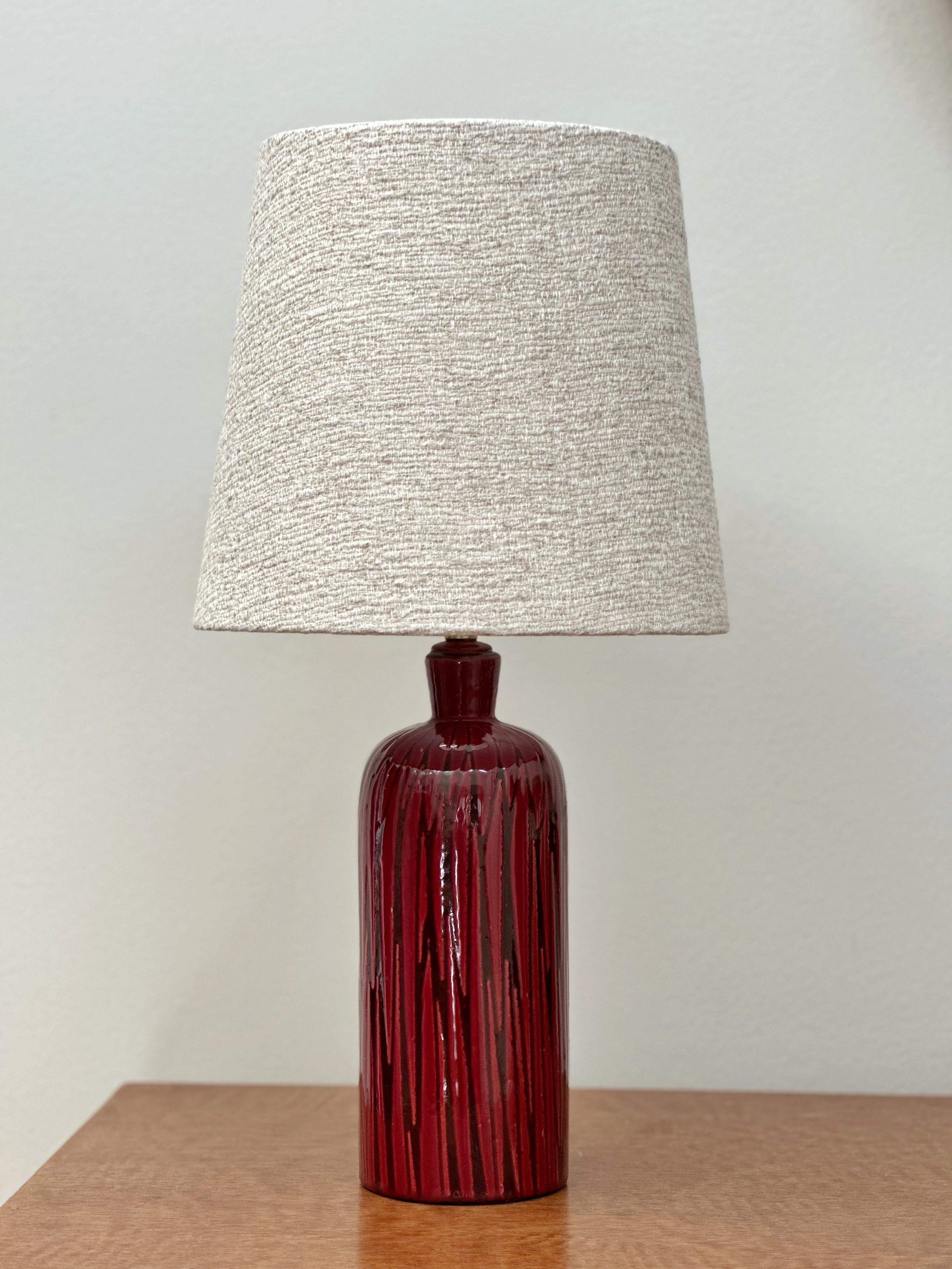 Upsala Ekeby Stoneware Table Lamp TOKYO 4093  in a burgundy red tone. Graphic, Organic and Playful Pattern in black. Design by Mari Simmulson for Swedish Upsala-Ekeby in the 1960s.
Great Vintage Condition with only light signs of use. The lamp has