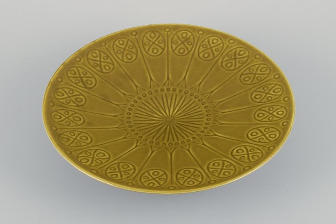 Upsala Ekeby/Gefle, Sweden. Large ceramic centerpiece. 
Geometric pattern. Green-yellow glaze.
Marked.
Mid-20th century.
In excellent condition.
Dimensions: Diameter 30.0 cm x Height 6.5 cm.