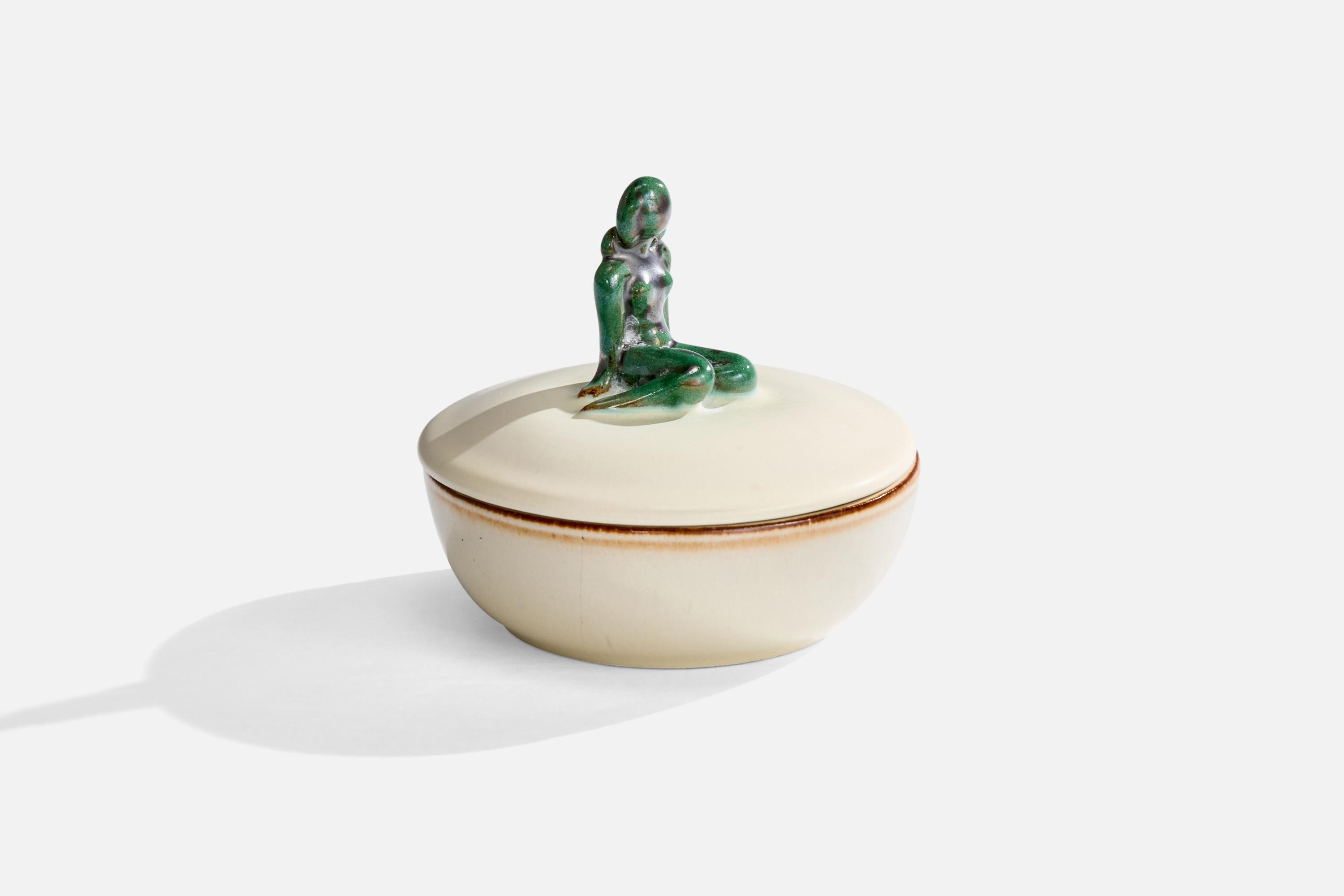 Jarra con tapa de loza vidriada en blanco y verde producida por Upsala Ekeby, Suecia, c. 1930.

Desgaste propio de la edad y el uso

Dimensiones totales (pulgadas): 4,0