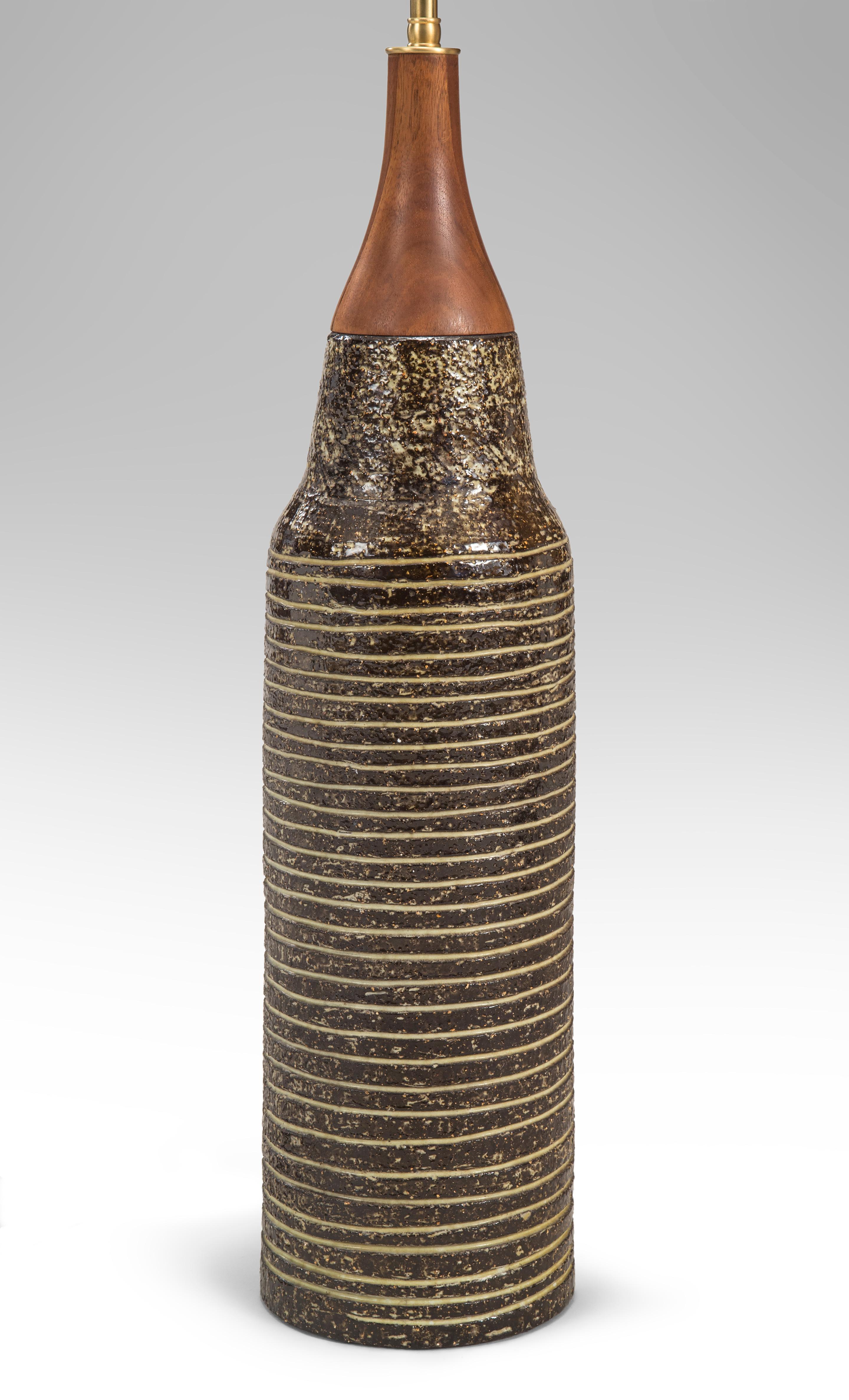 Upsala-Ekeby, Swedish Stoneware lamp, Marked: UE Sweden 2432
circa 1970
A classic studio ceramic with a vibrant glaze and handsomely articulated form. The tapering wooden neck above the columnar body adorned with deeply cut concentric rings.