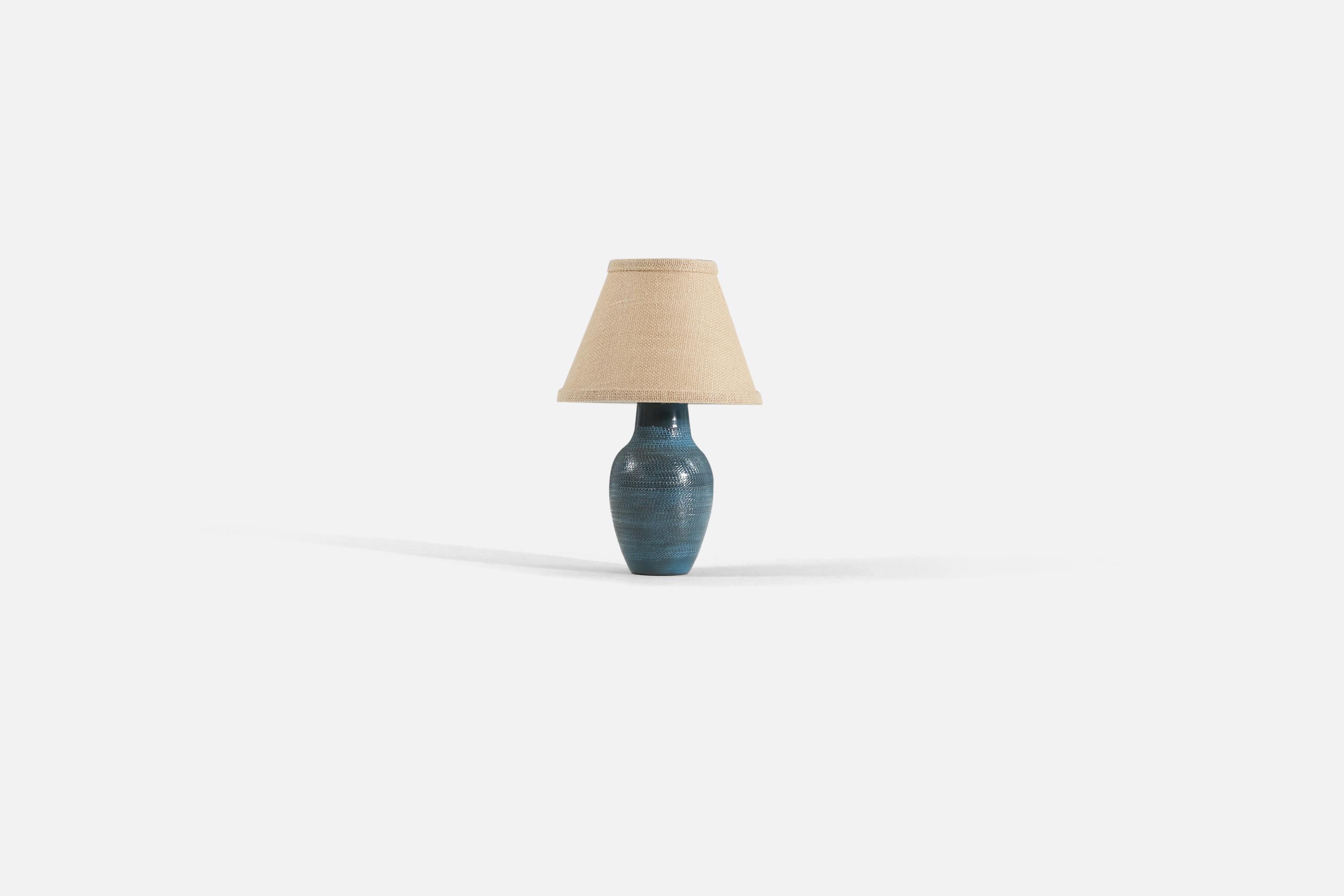 A blue glazed earthenware table lamp designed by Ingrid Atterberg and produced by Upsala-Ekeby, Sweden, c. 1950s. 

Measurements listed are of lamp. Sold without lampshade.

For reference:

Shade : 4.25 x 8.25 x 6
Lamp with shade : 12.5 x 8.25 x 8.25